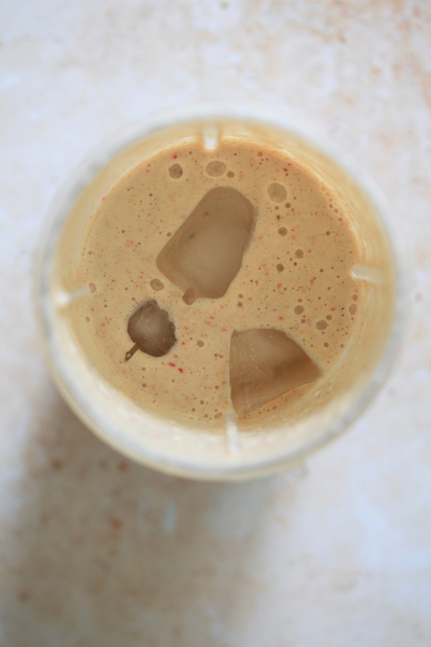 blended smoothie in blender with ice cubes