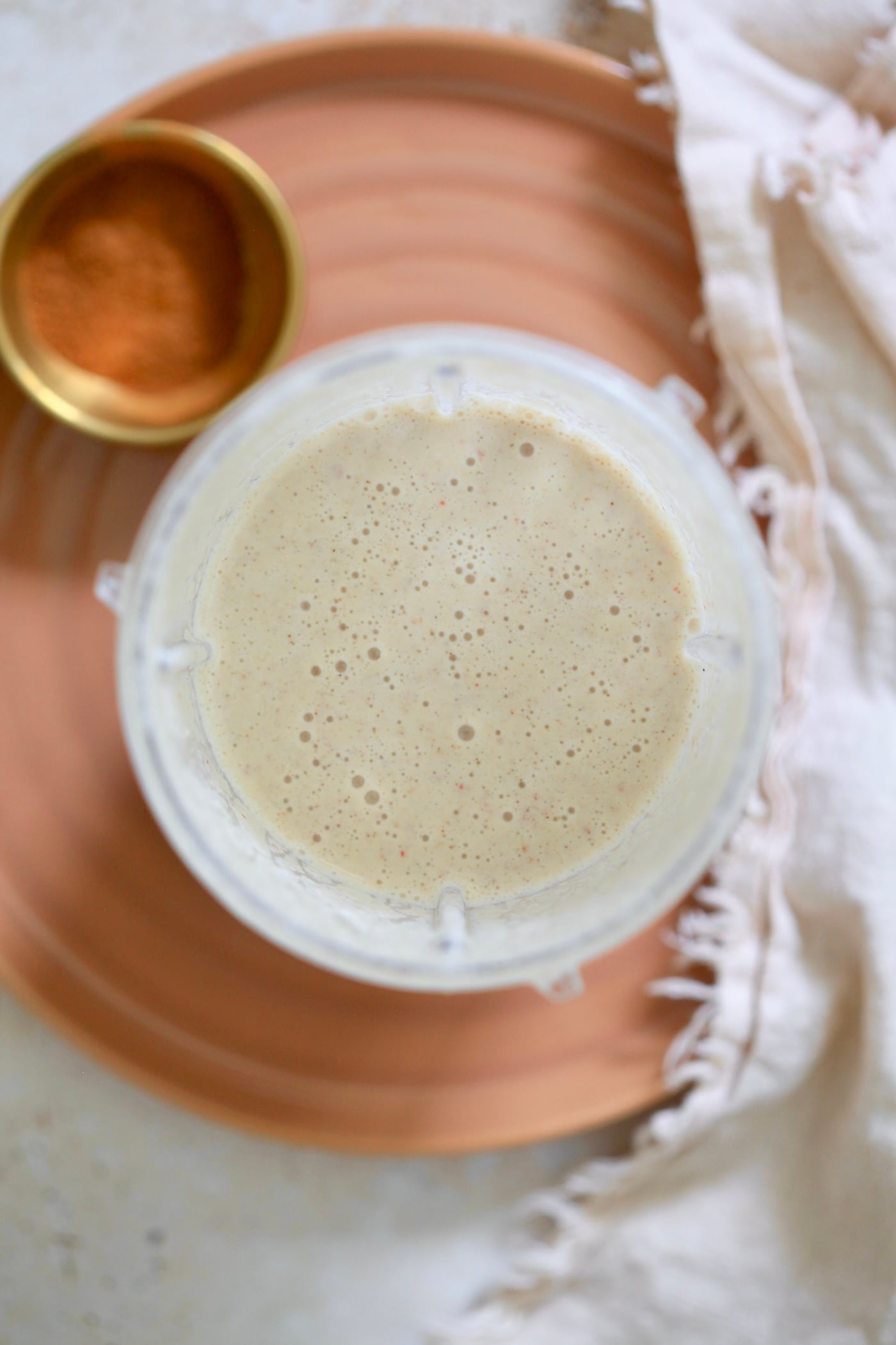 blended smoothie in blender on brown plate