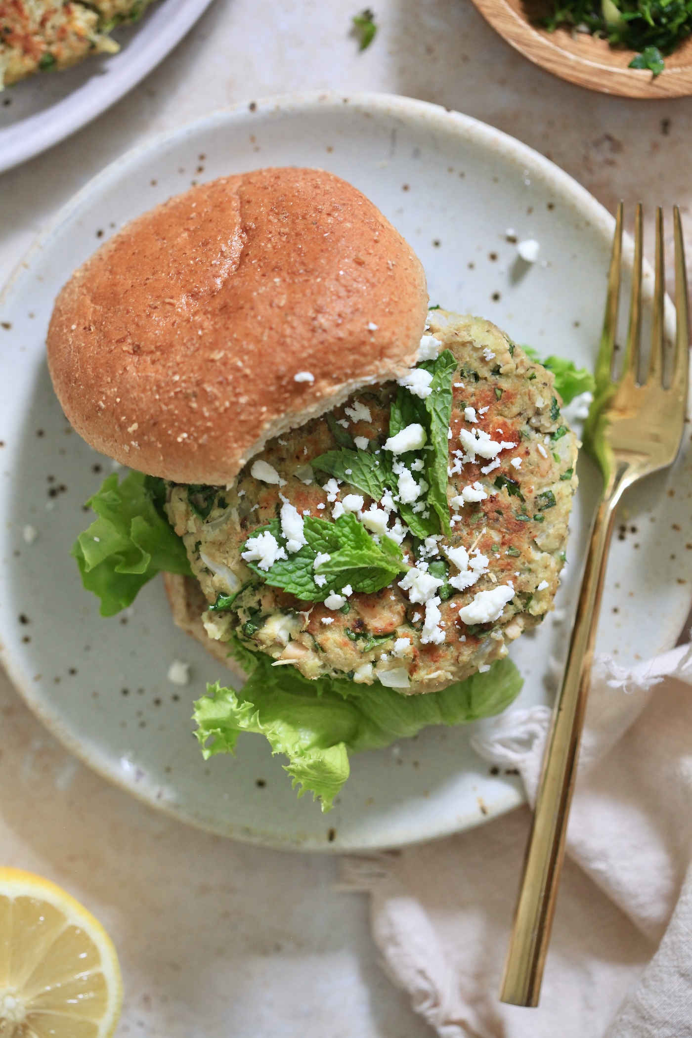 salmon burger on bun with feta and herbs