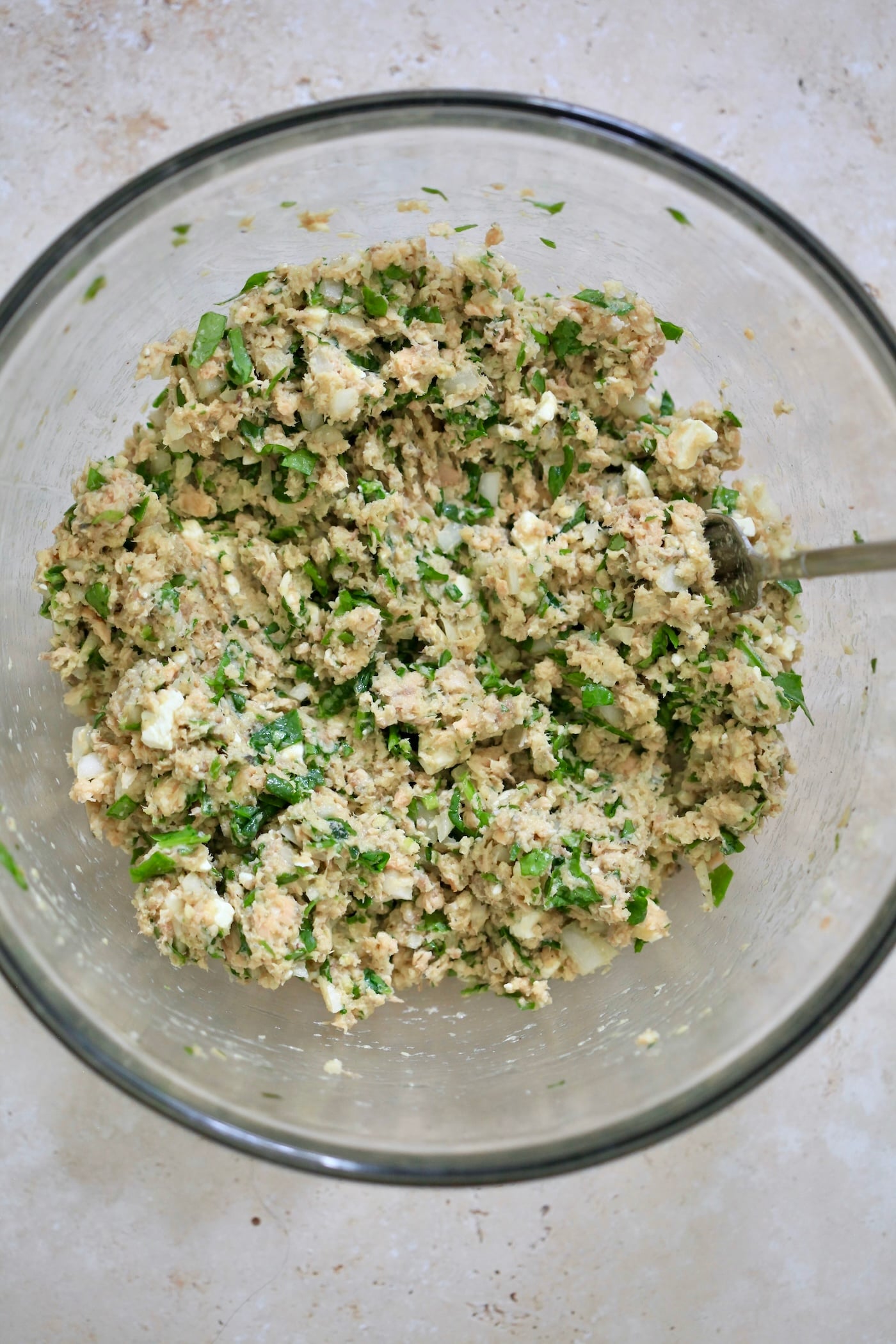 salmon mixture with chopped spinach in mixing bowl.
