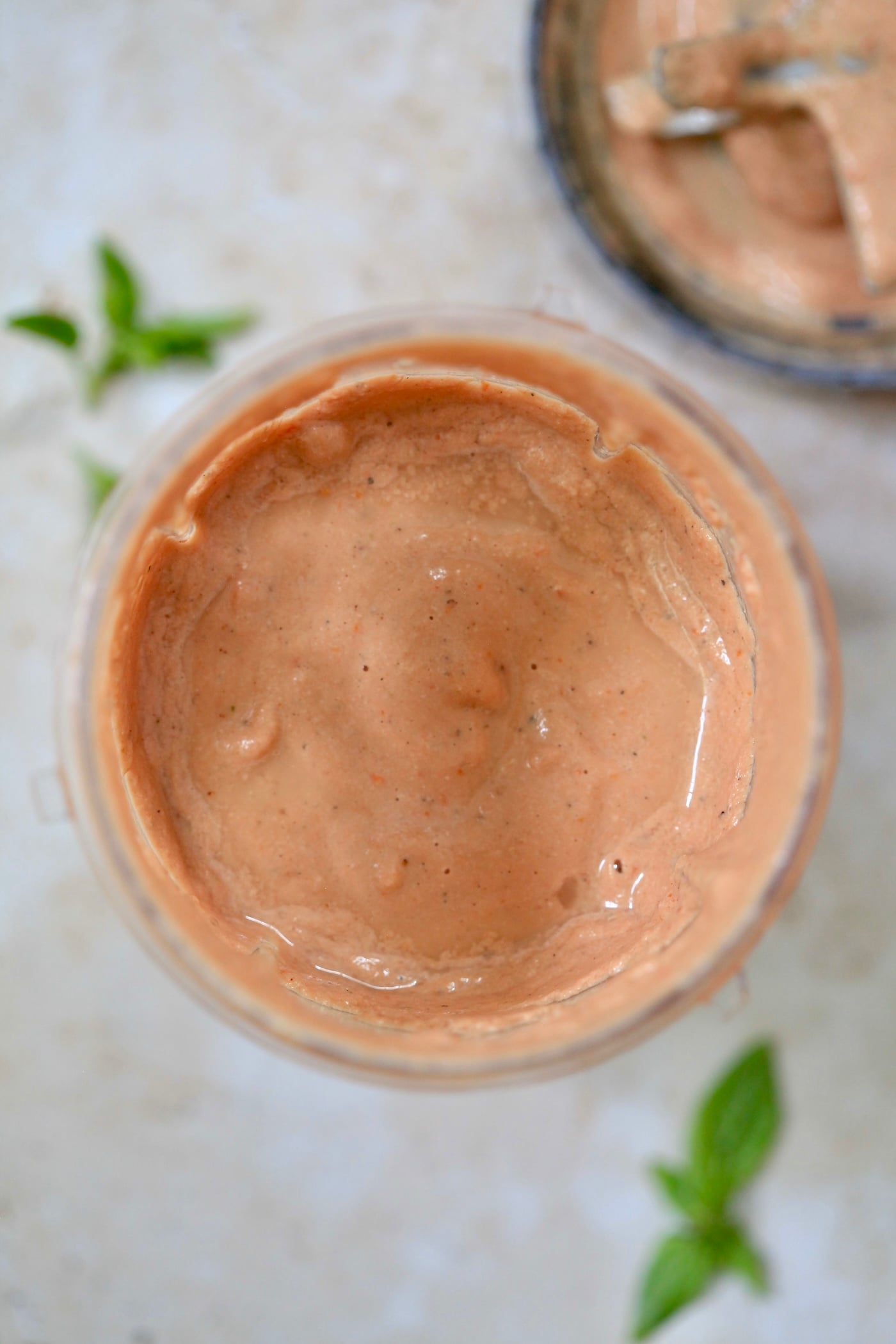 blended red sauce in cup with basil.
