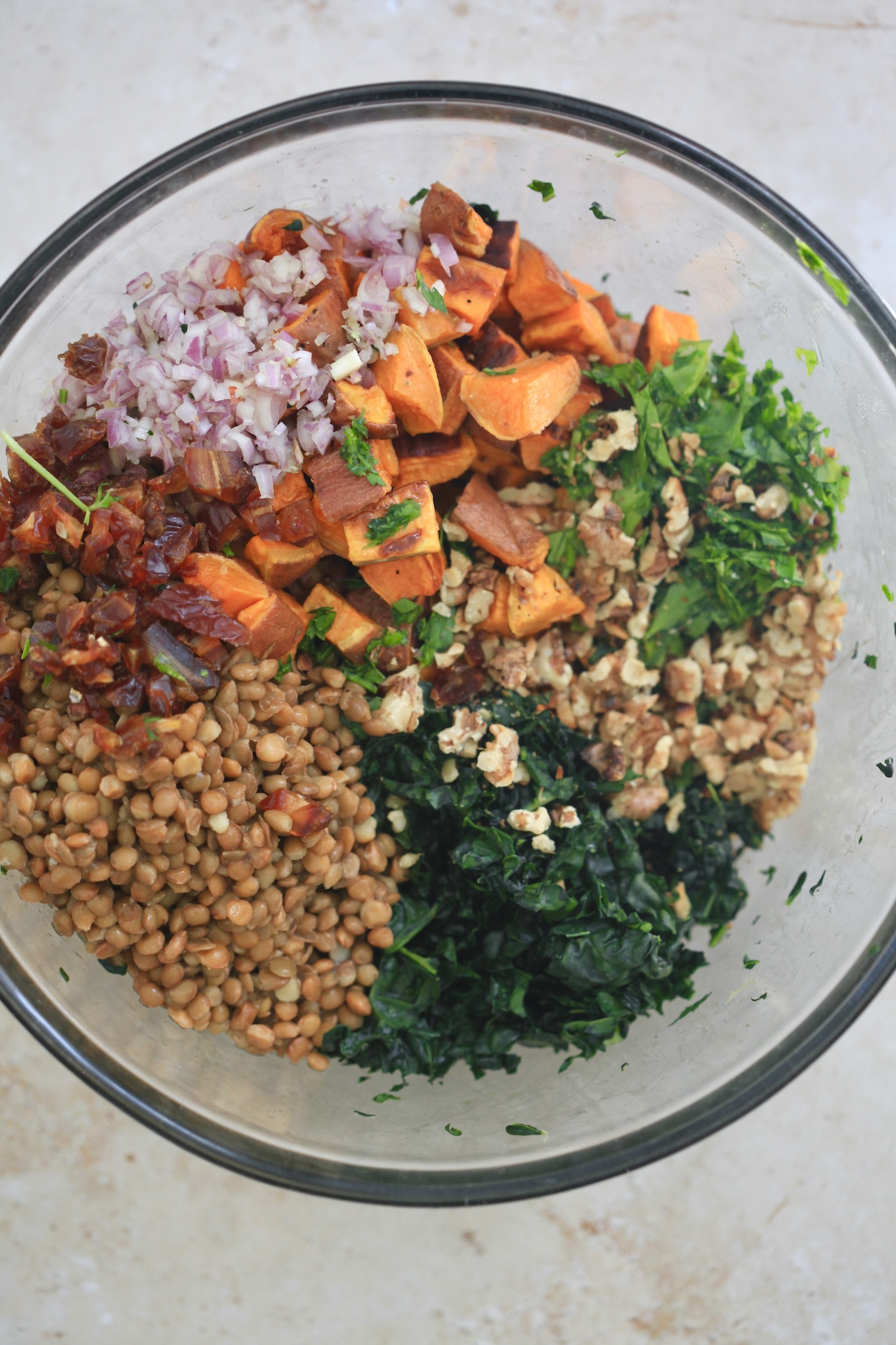 kale, lentils, and sweet potatoes in mixing bowl.