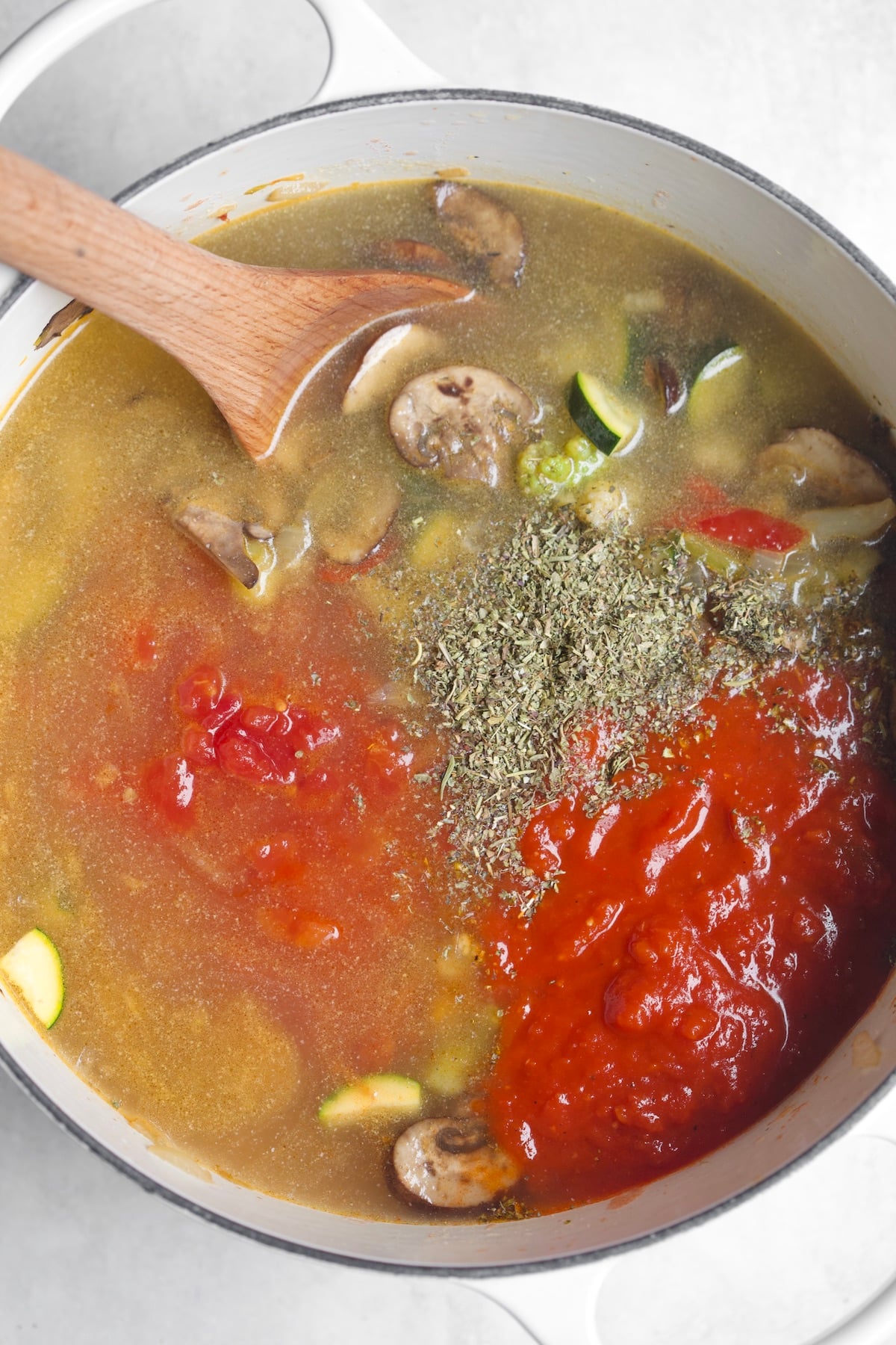 adding water and tomato sauce to pot
