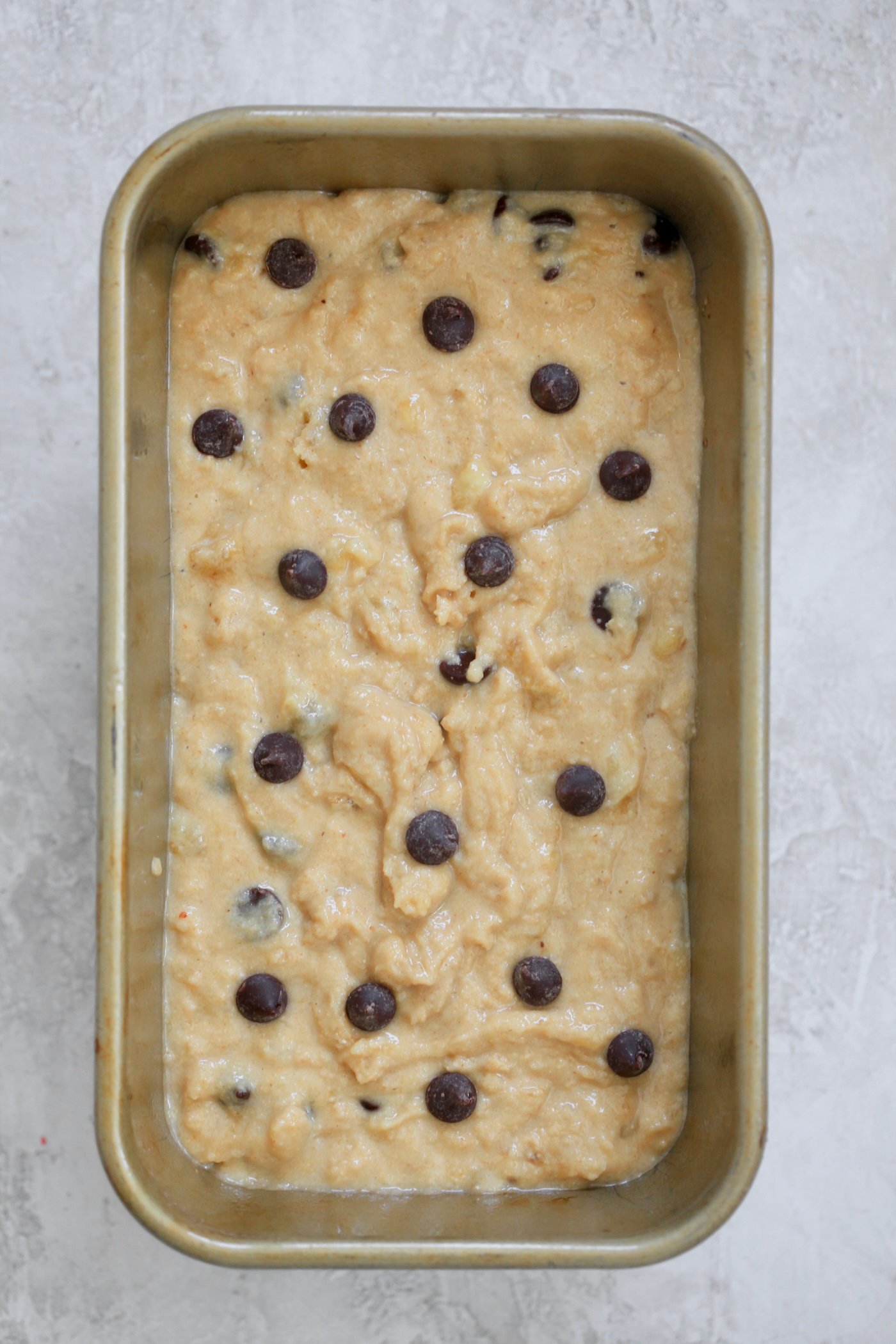 unbaked banana bread in gold pan.