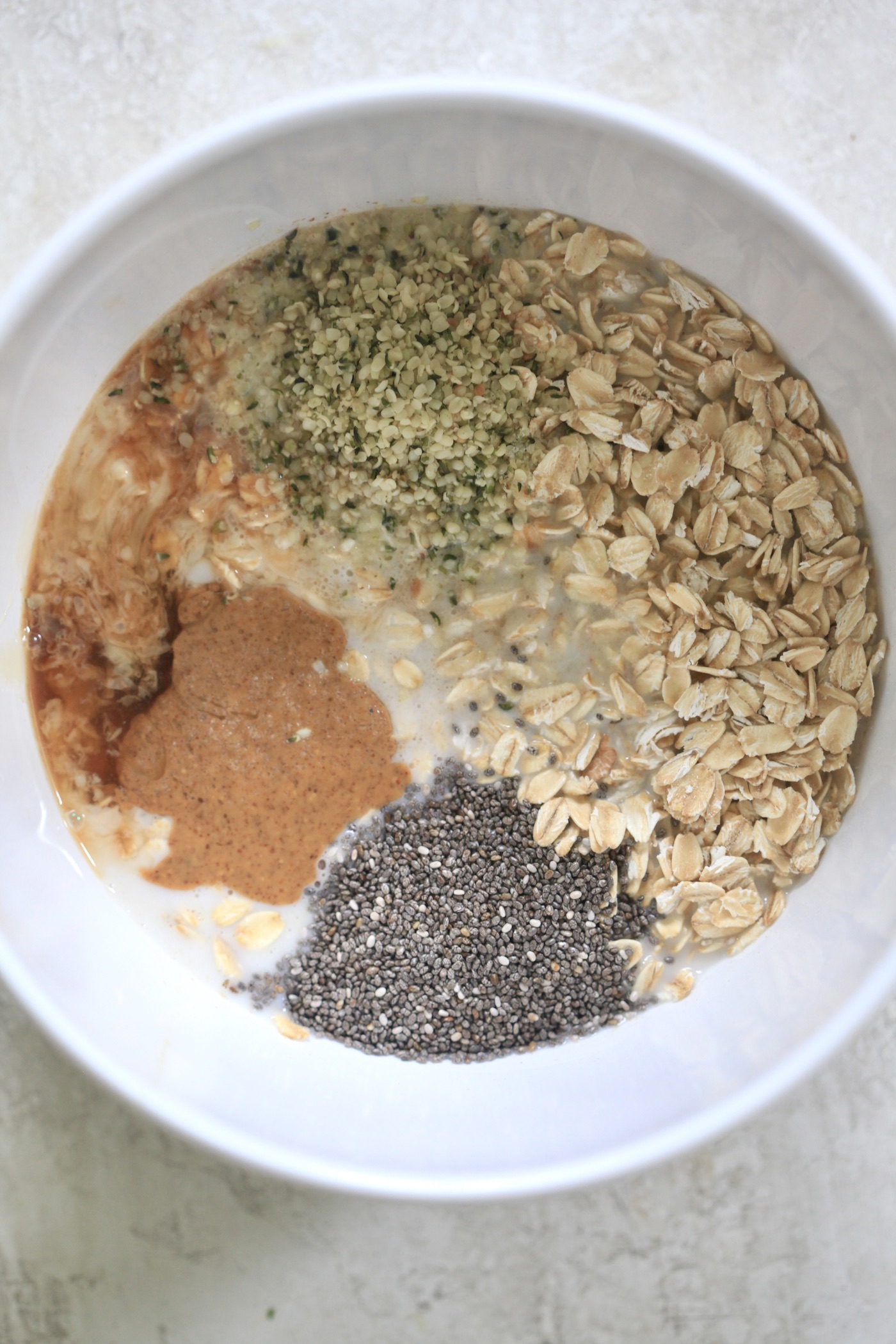 bowl with oats, almond butter, milk and seeds