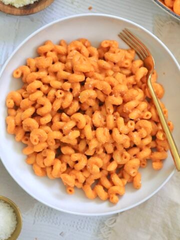 bowl of red pasta with gold fork.