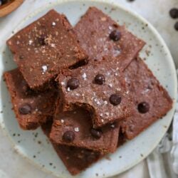 plate of brownies with bite taken out of one.