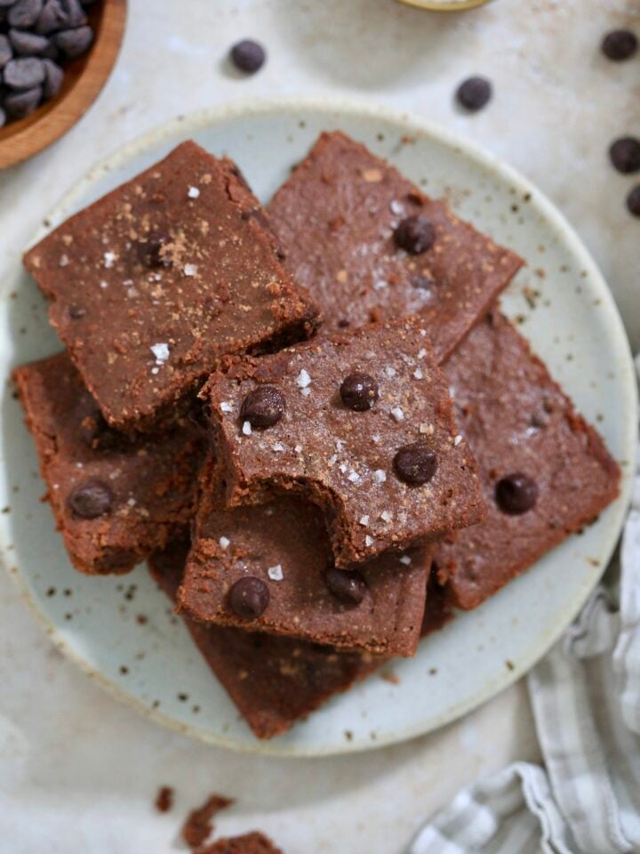 plate of brownies with bite taken out of one.