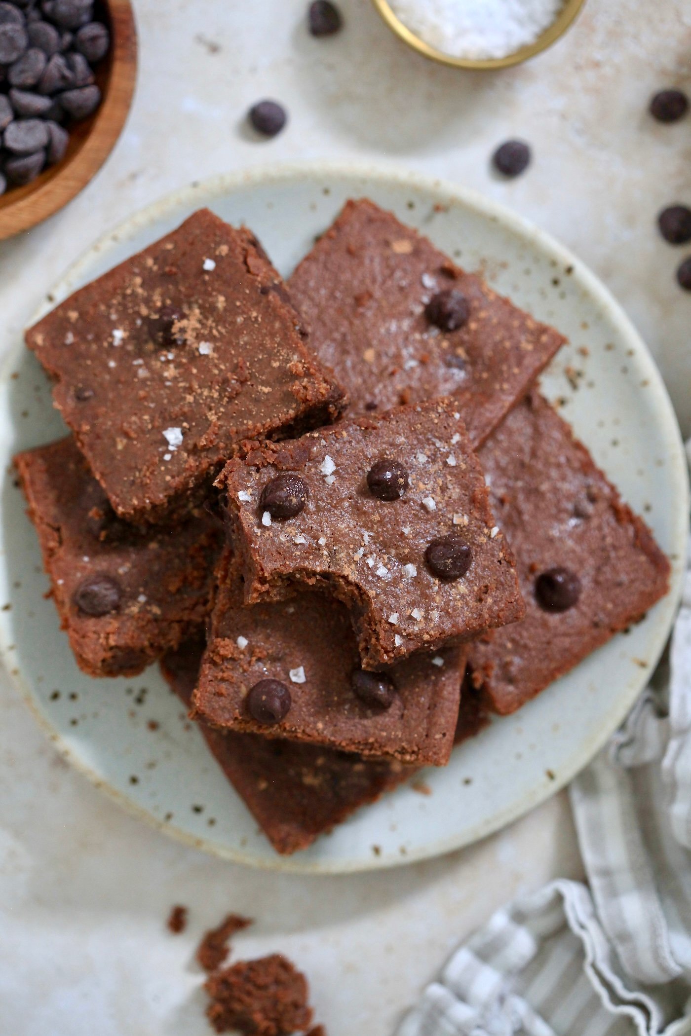 plate of brownies with bite taken out of one.