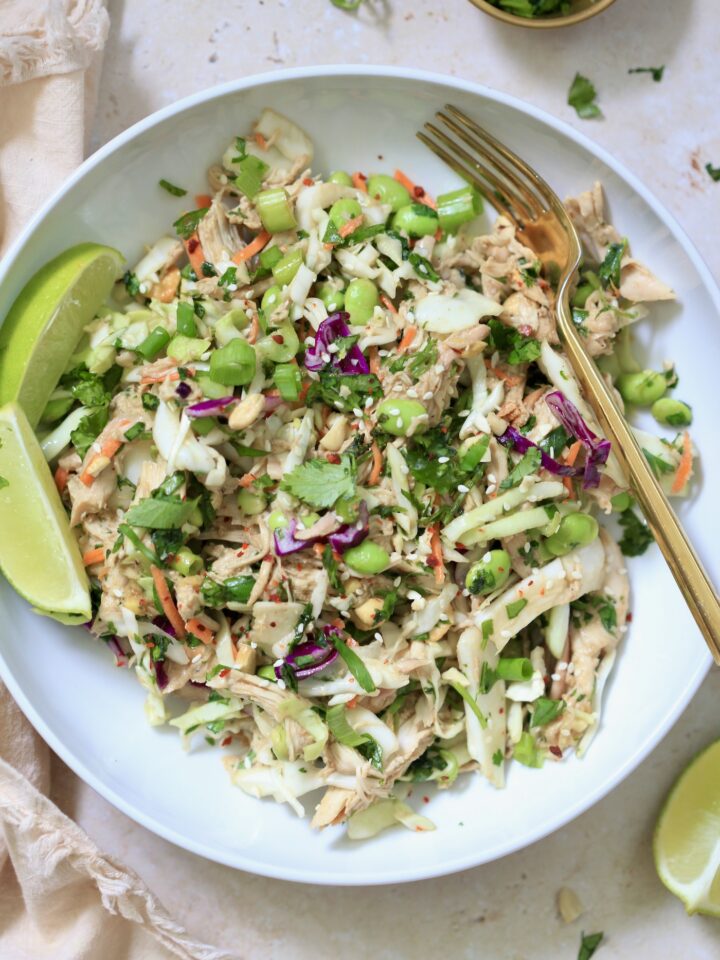 bowl of cabbage chicken salad with colorful veggies.