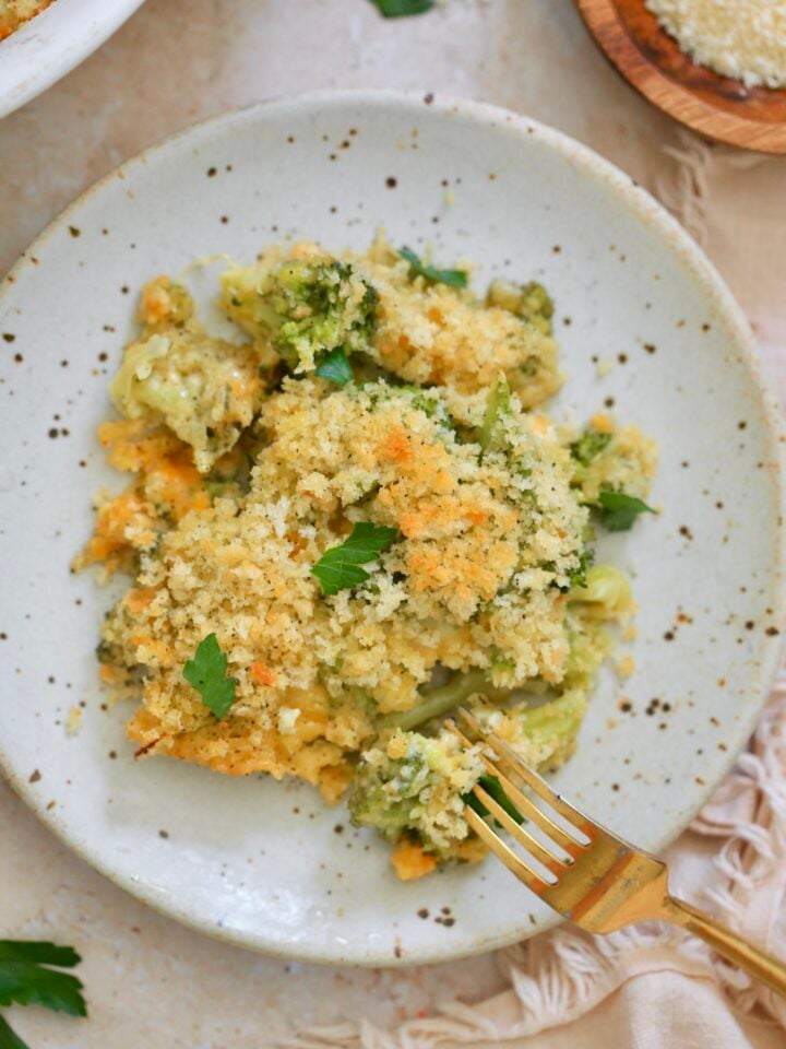 plate with piece of casserole topped with breadcrumbs and green herb.