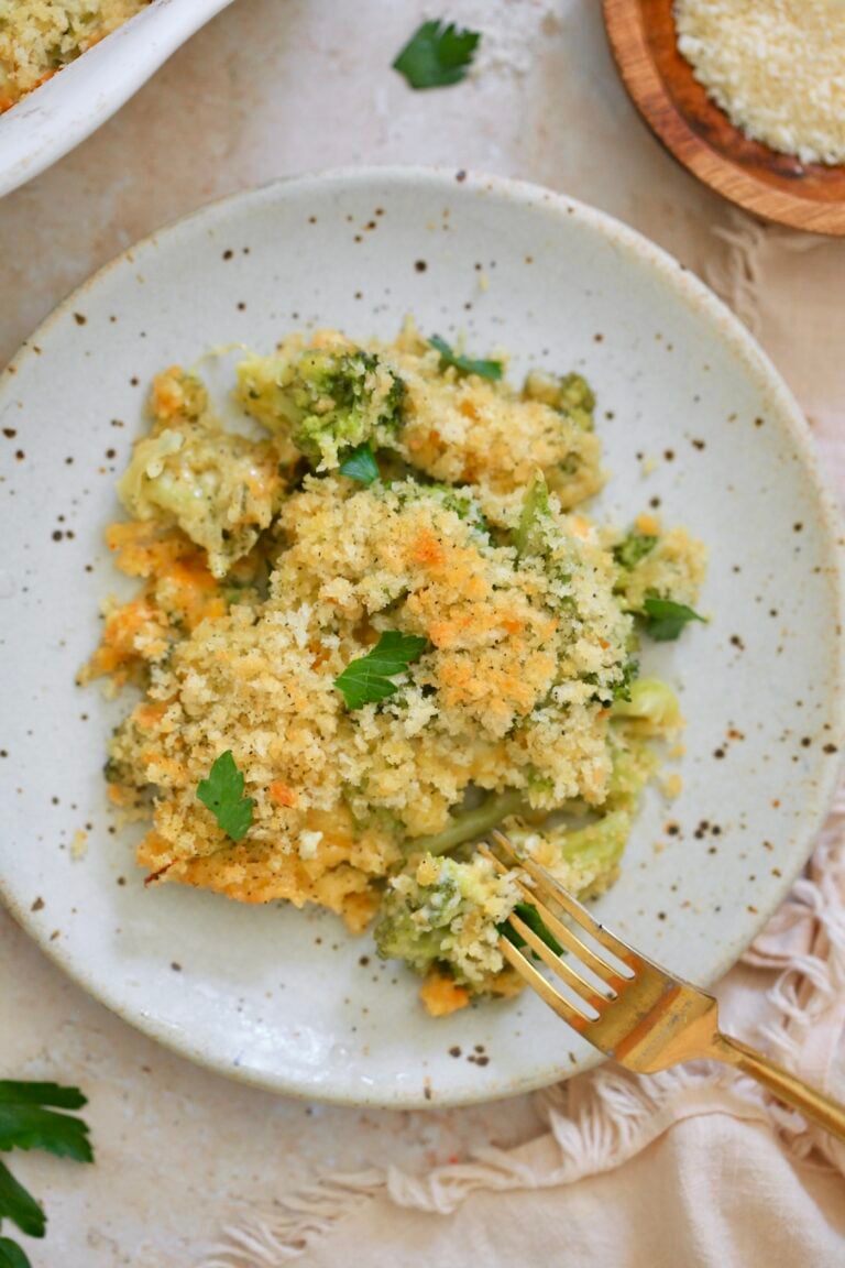 plate with piece of casserole topped with breadcrumbs and green herb.