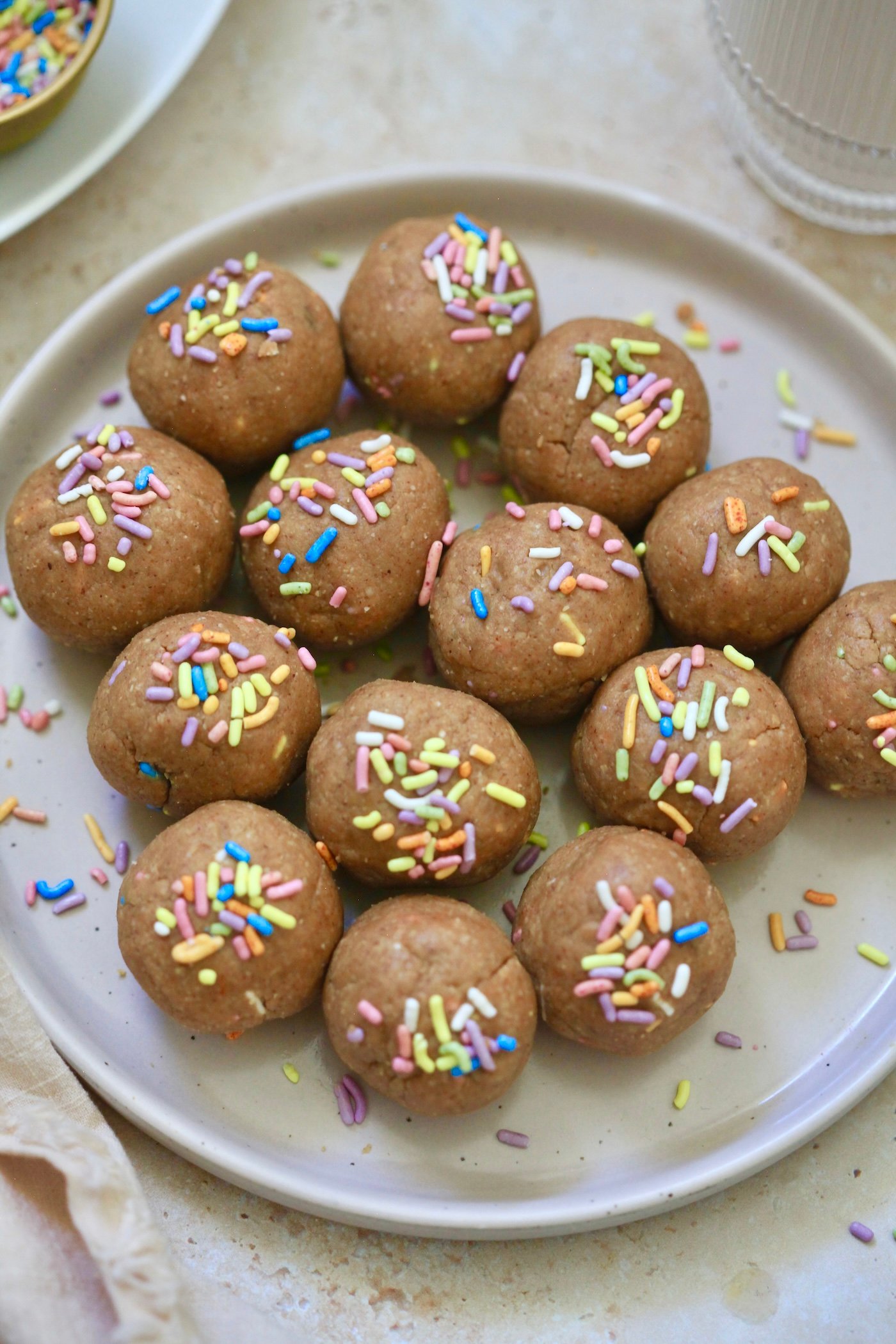 up close light brown balls with sprinkles on plate