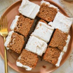 orange plate with several pieces of frosted pumpkin cake