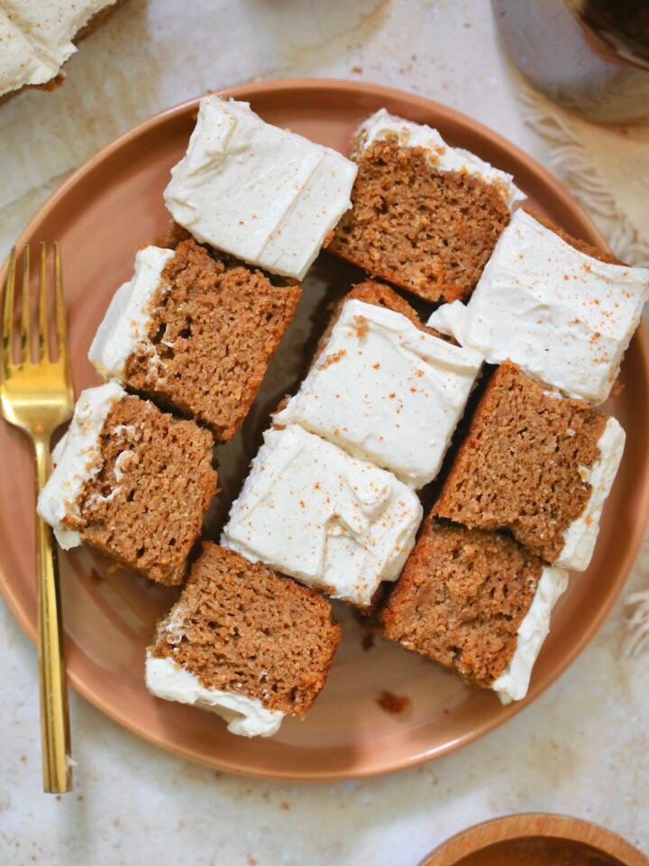 orange plate with several pieces of frosted pumpkin cake