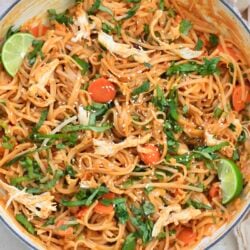 white pan with colorful noodles in red sauce.