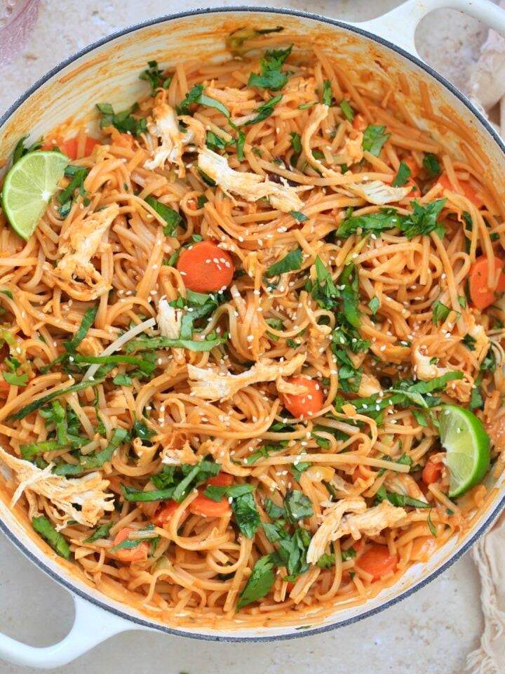 white pan with colorful noodles in red sauce.