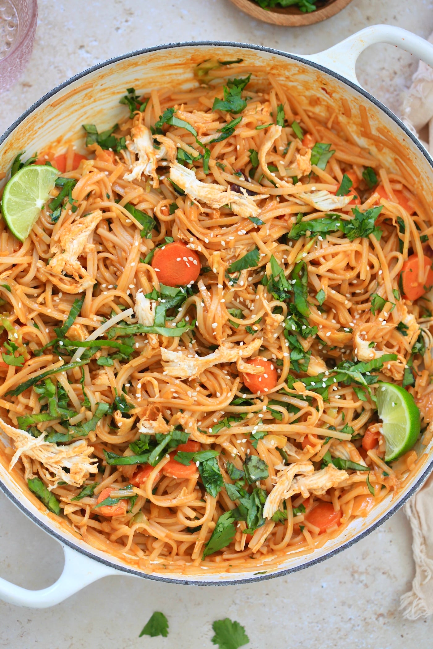 white pan with colorful noodles in red sauce.