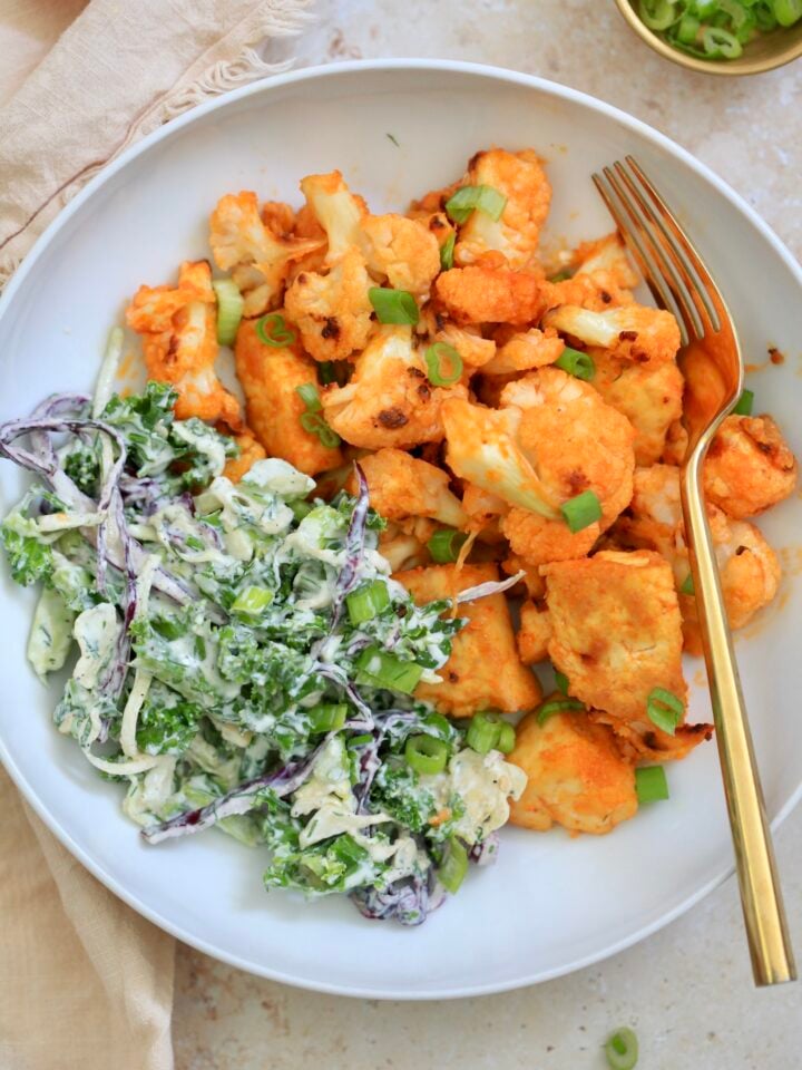 orange veggies with green slaw in white bowl.