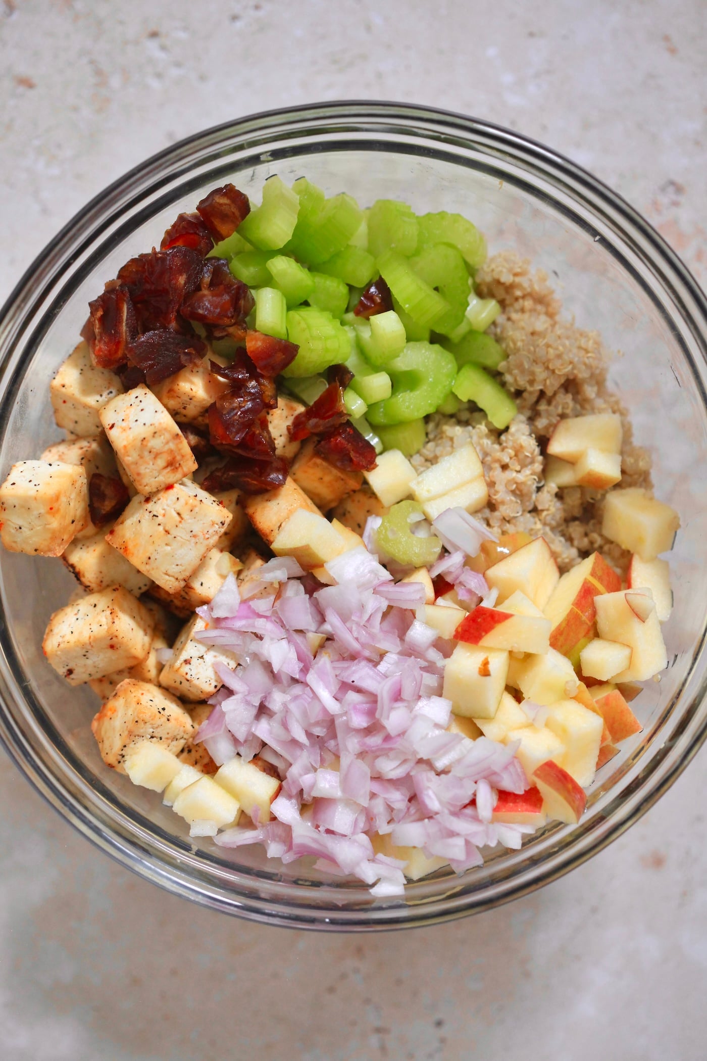 mixing bowl with quinoa, tofu, celery, onion, apple