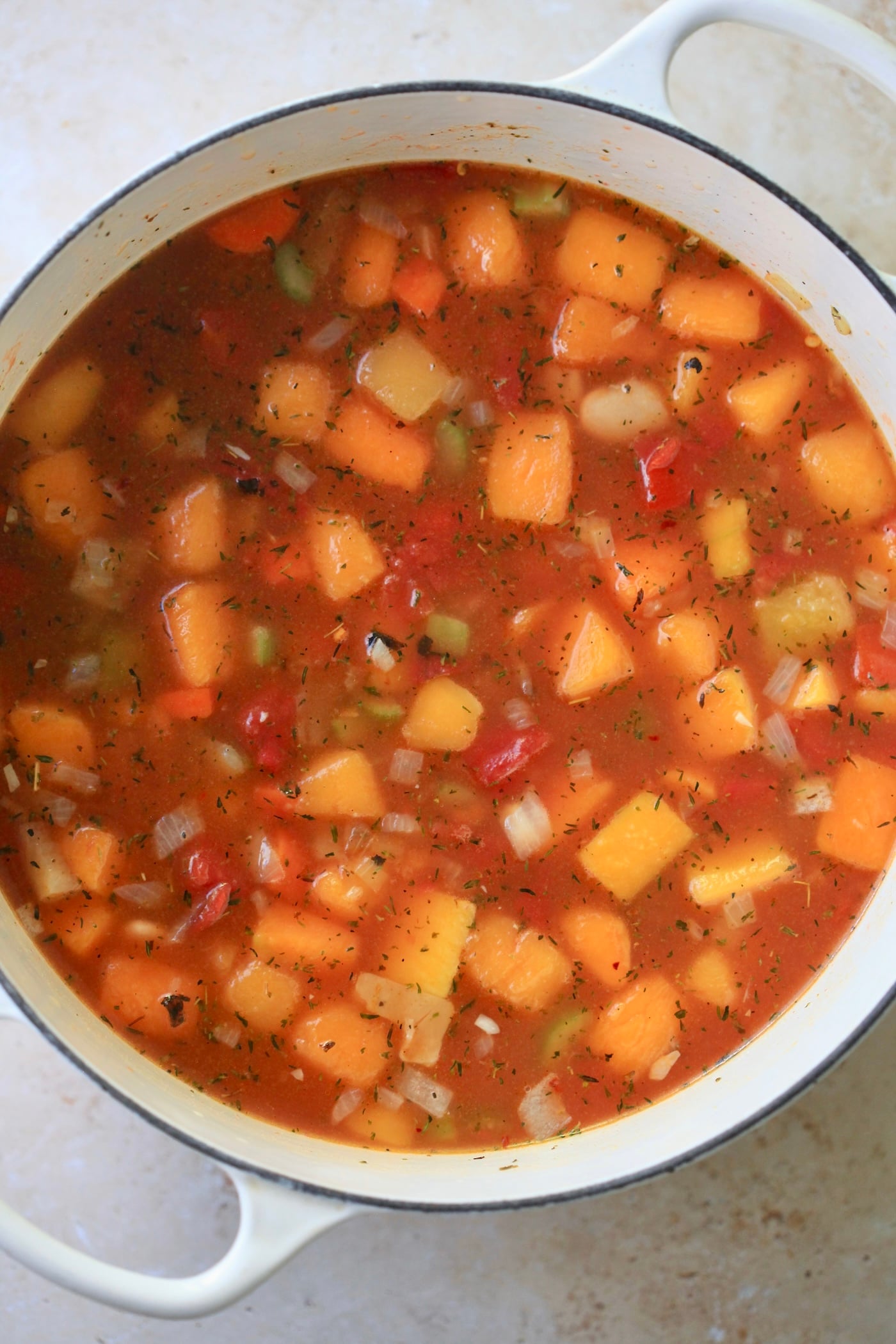 squash and red broth in soup pot.