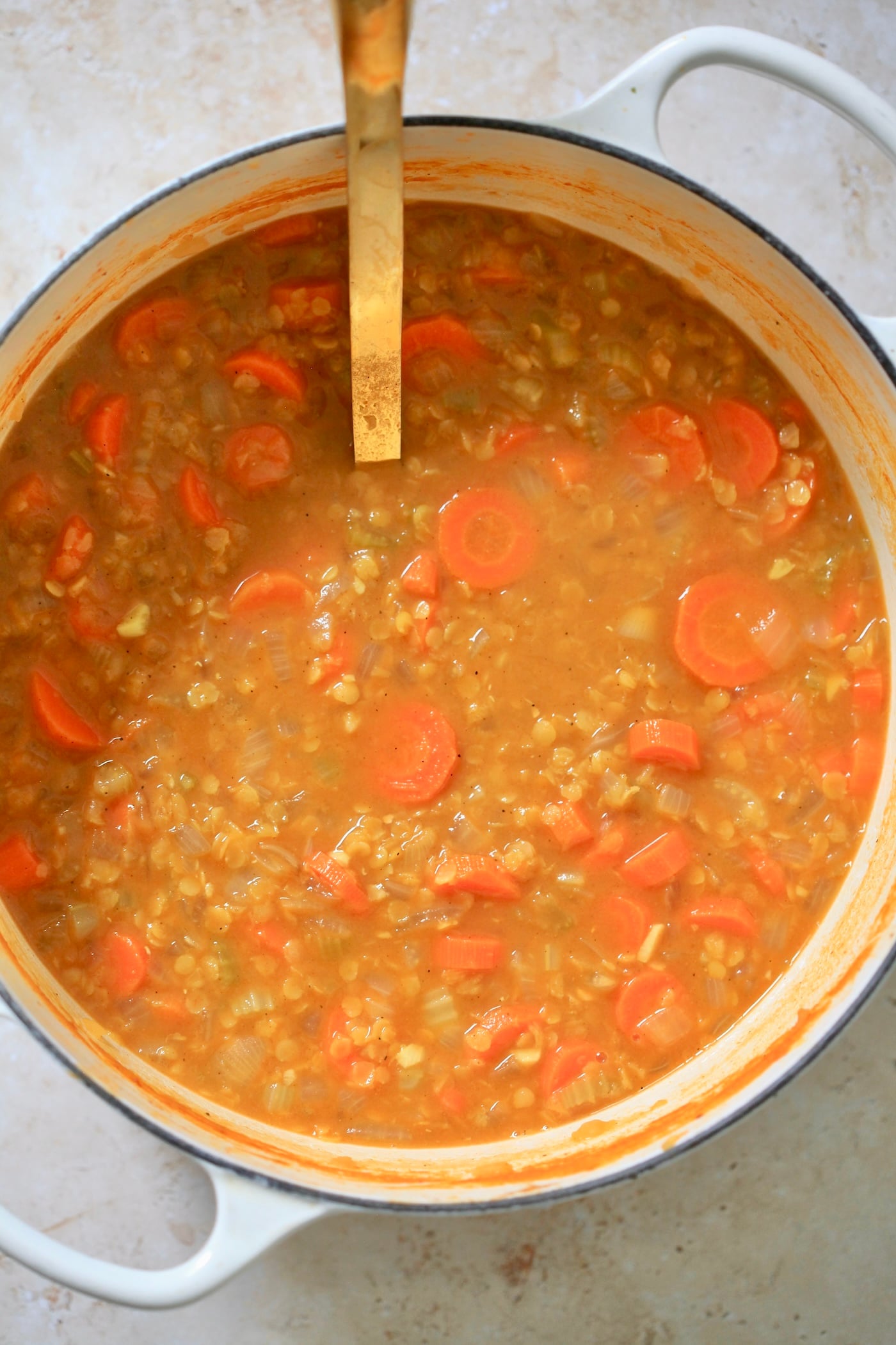 red lentil and carrot soup in pot.