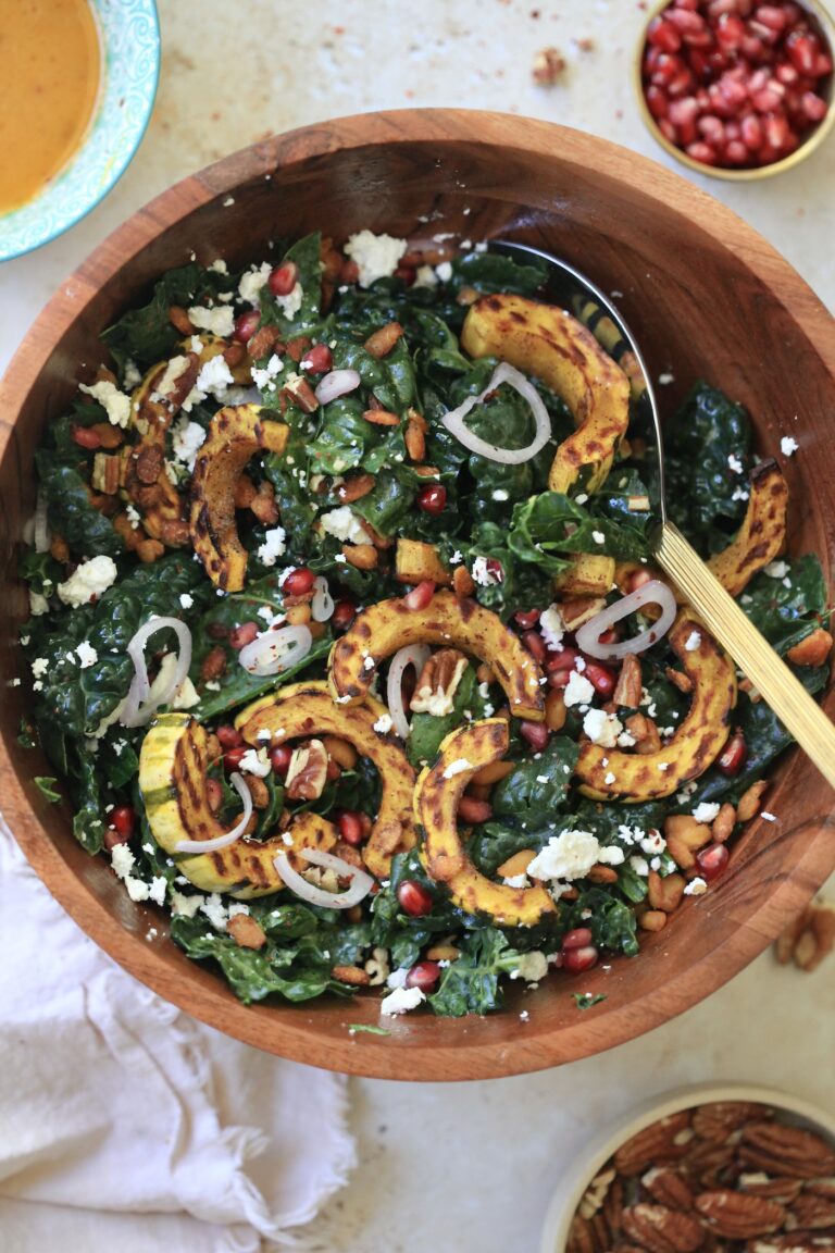 wooden bowl with kale salad and squash and serving spoon