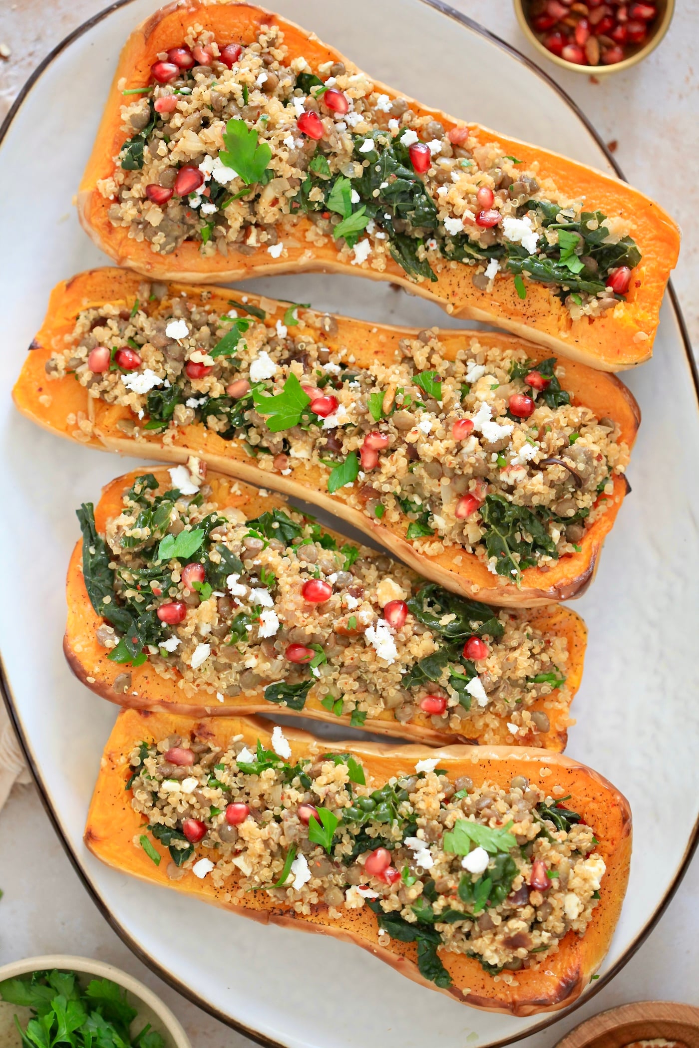 four stuffed squash halves on white platter.