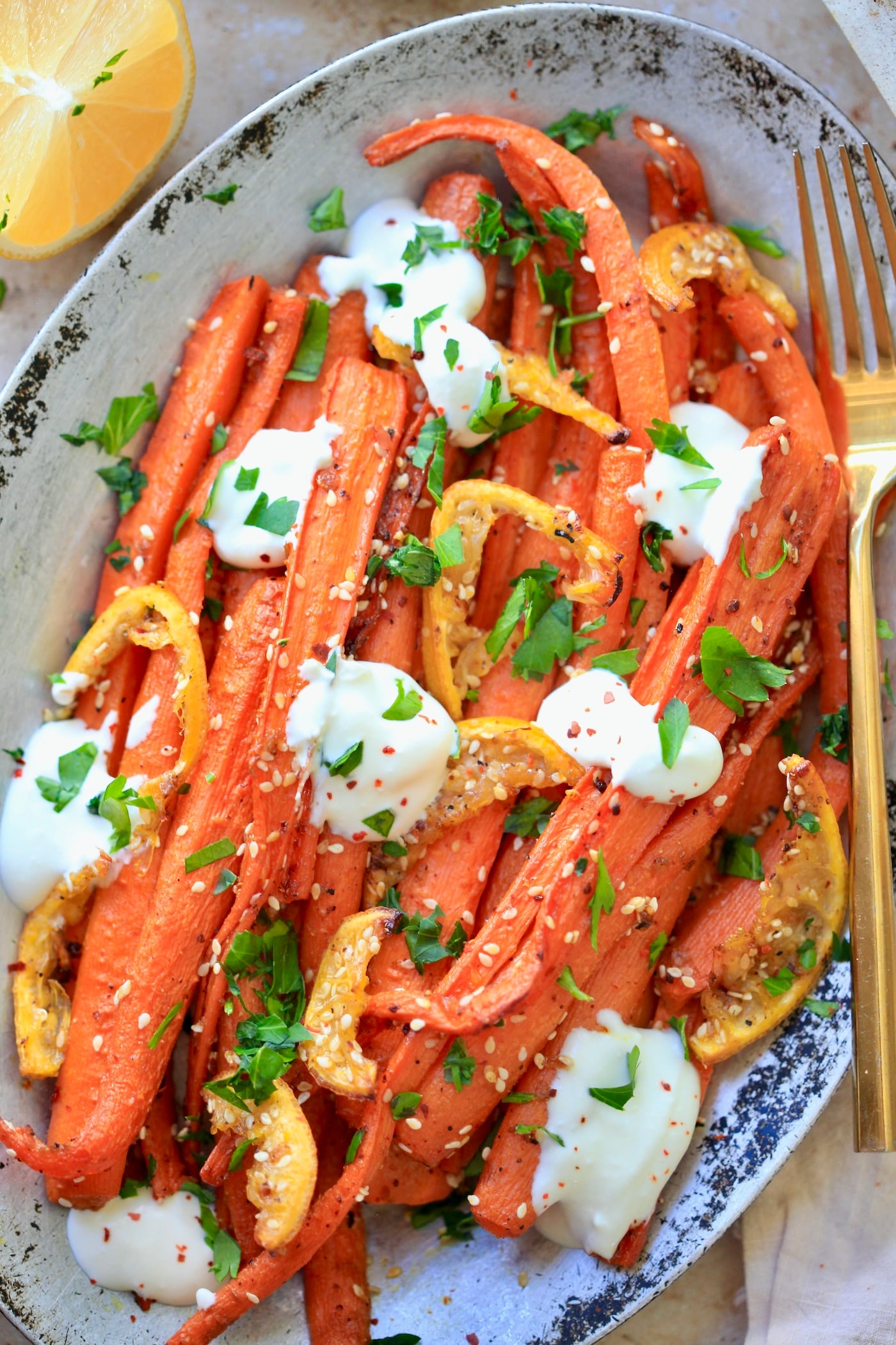 up close roasted whole carrots with white sauce.