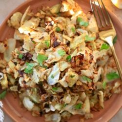 roasted green cabbage on brown plate with green fork