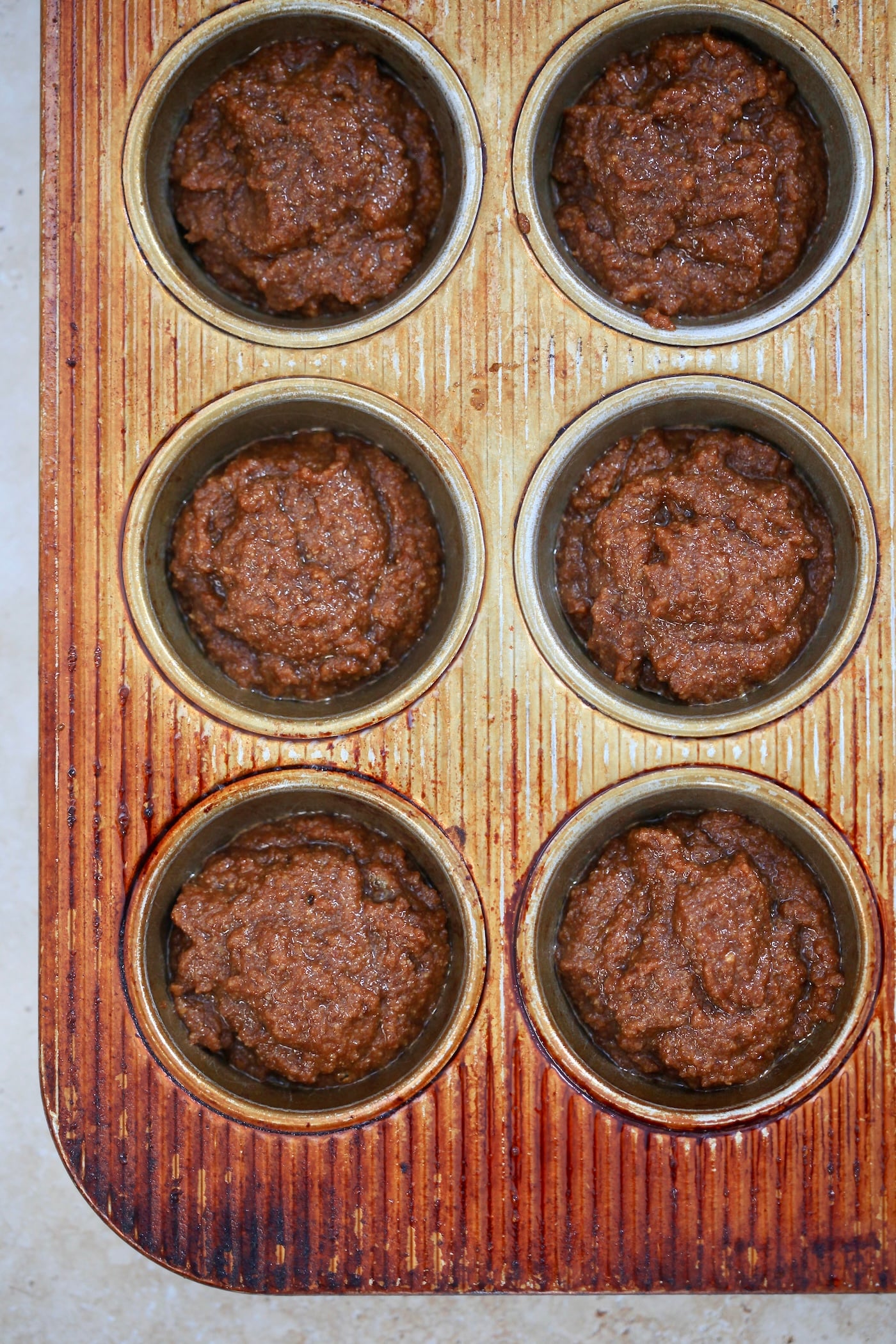 unbaked brown muffin batter in tin.