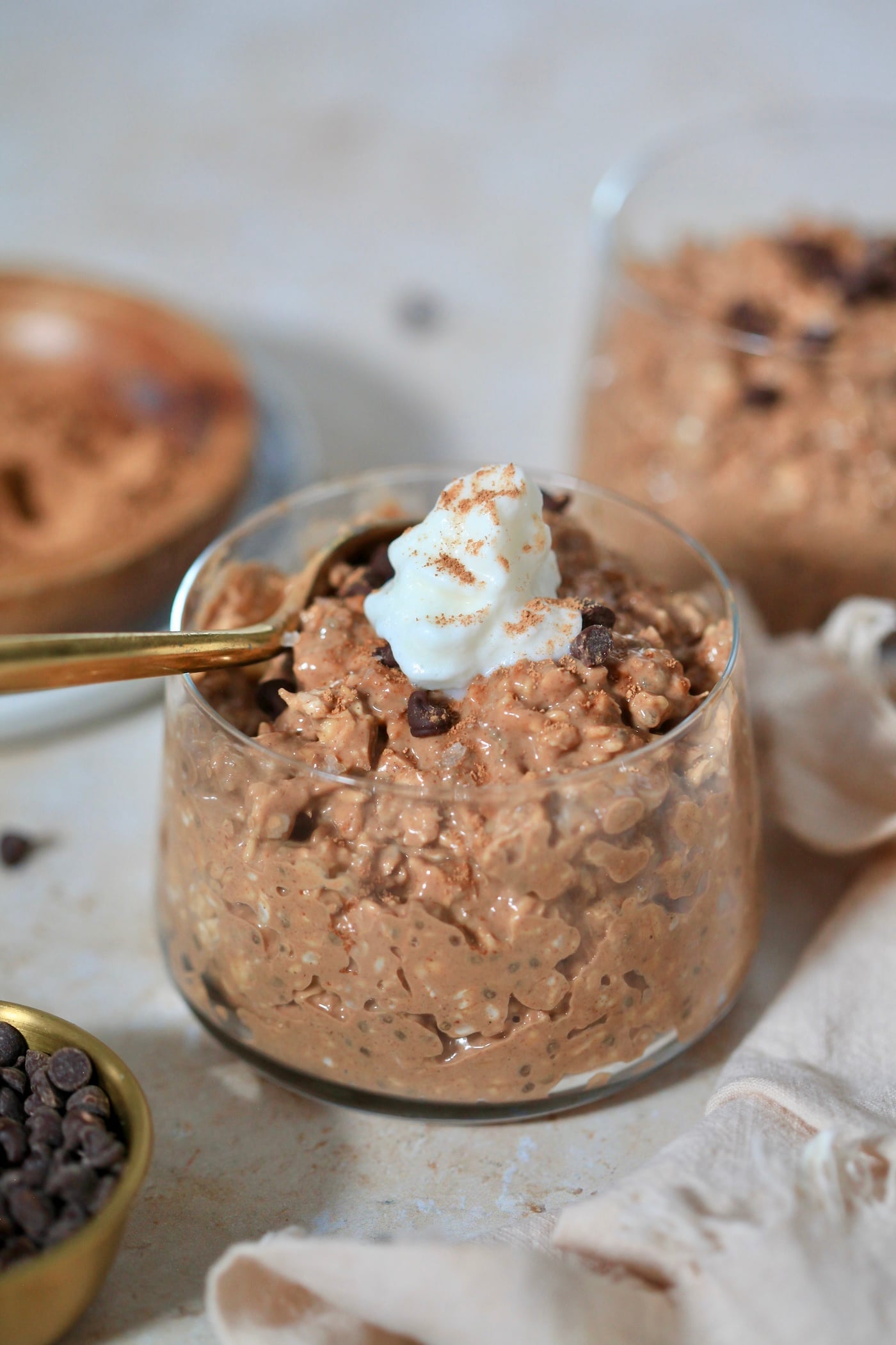 chocolate oats in glass with whipped cream on top.