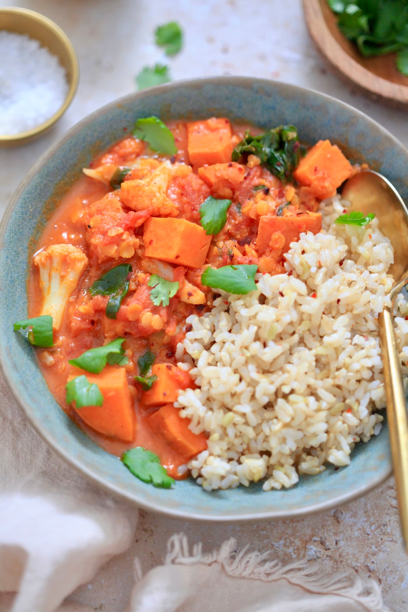 up close view of orange curry with rice in blue bowl.