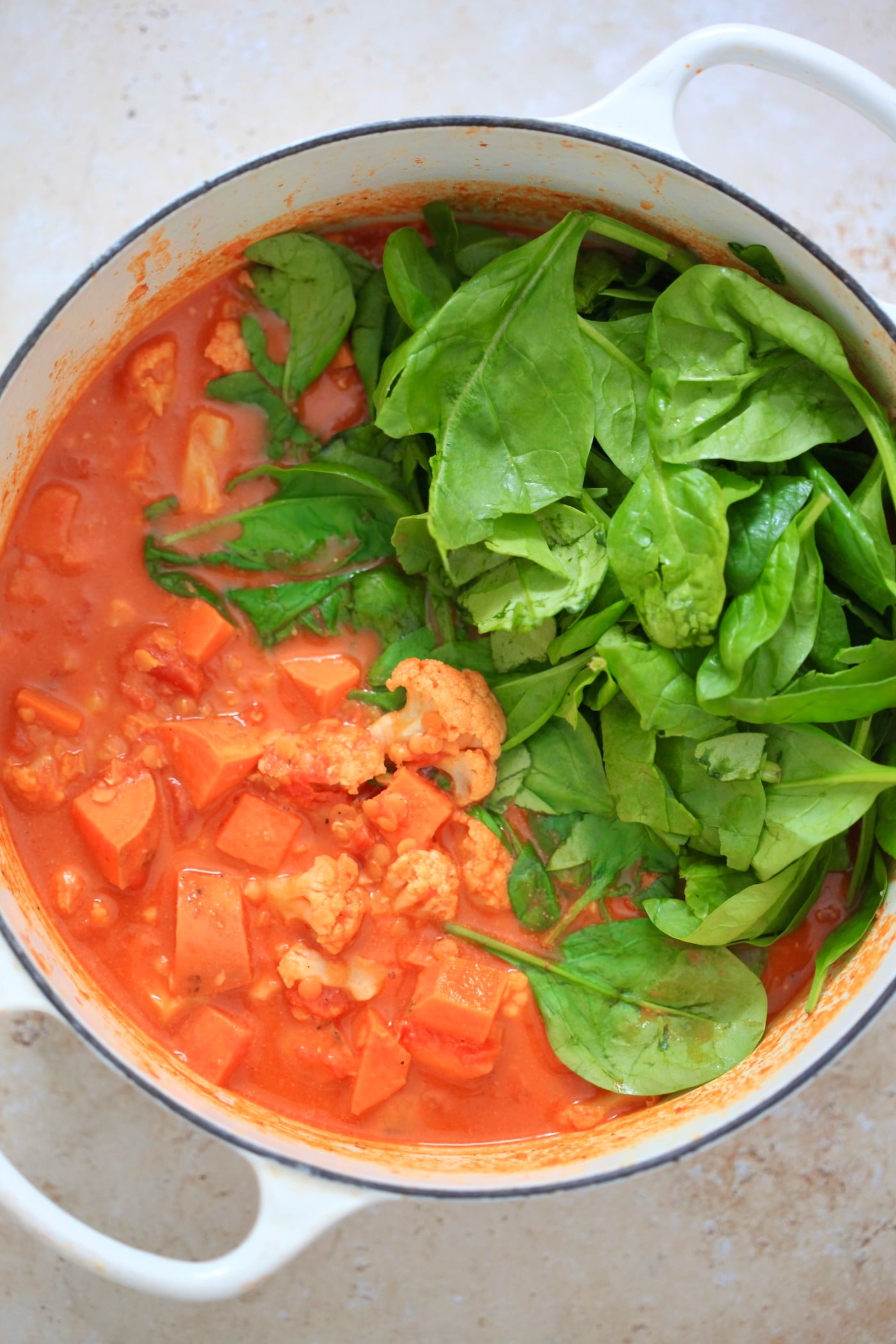 orange mixture with spinach in pan.
