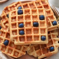 plate of big waffles with blueberries on top.