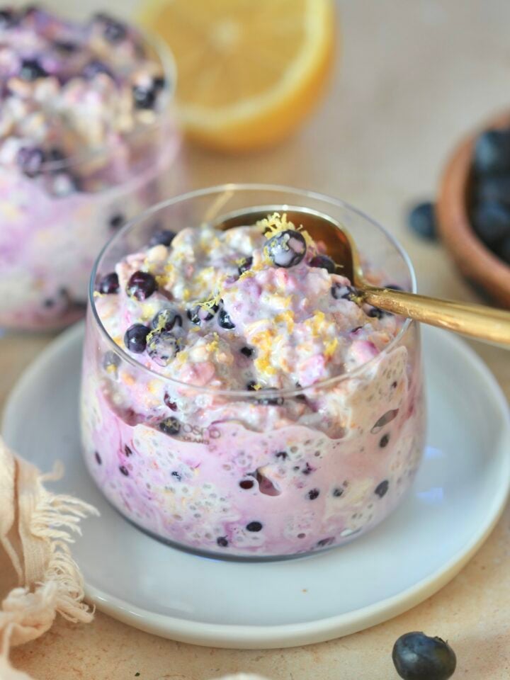 glass with blueberry oats and lemon in background.