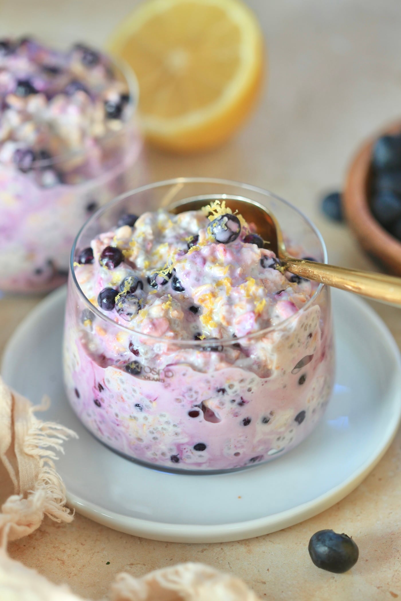 glass with blueberry oats and lemon in background.