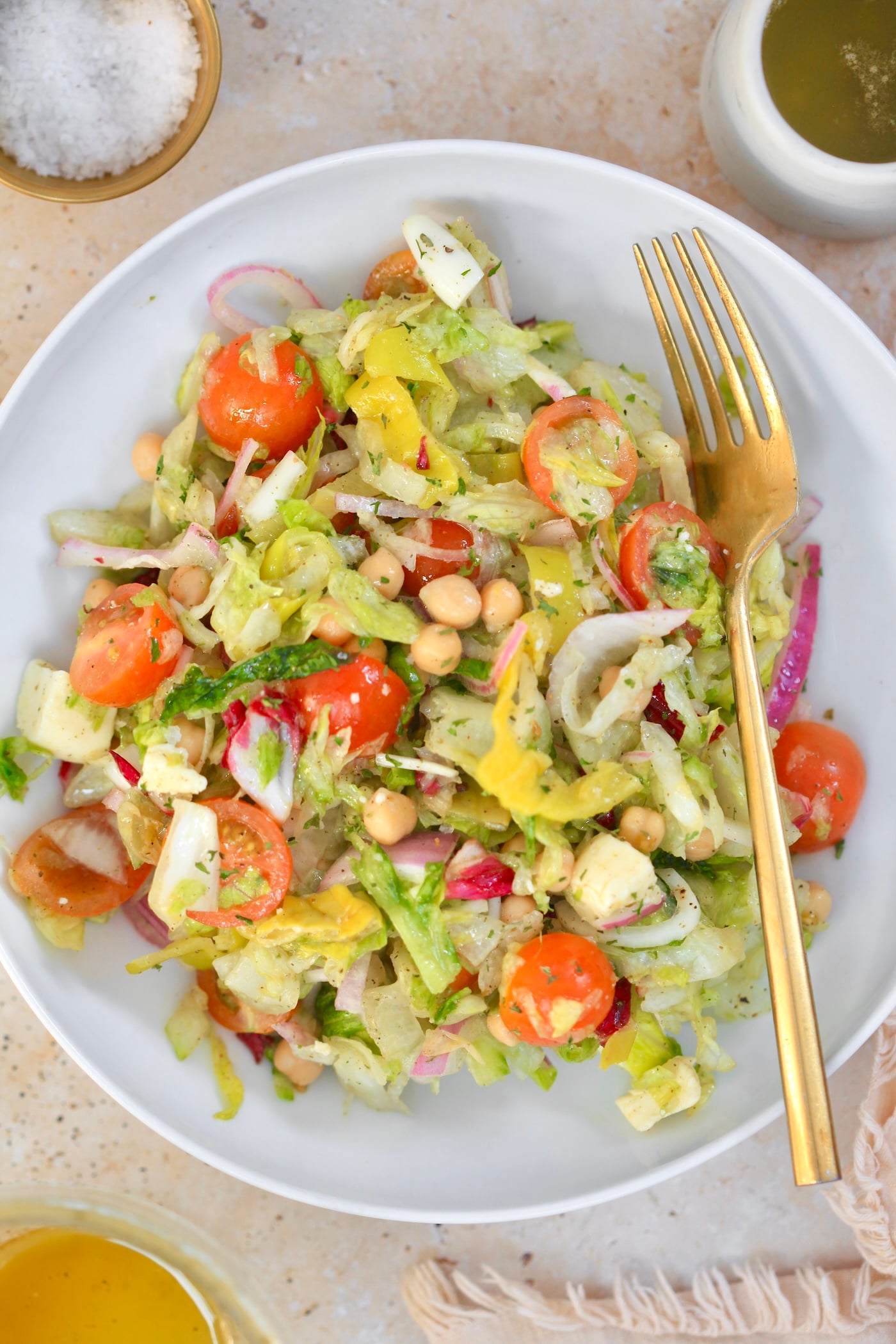 white bowl with chopped salad and gold fork.