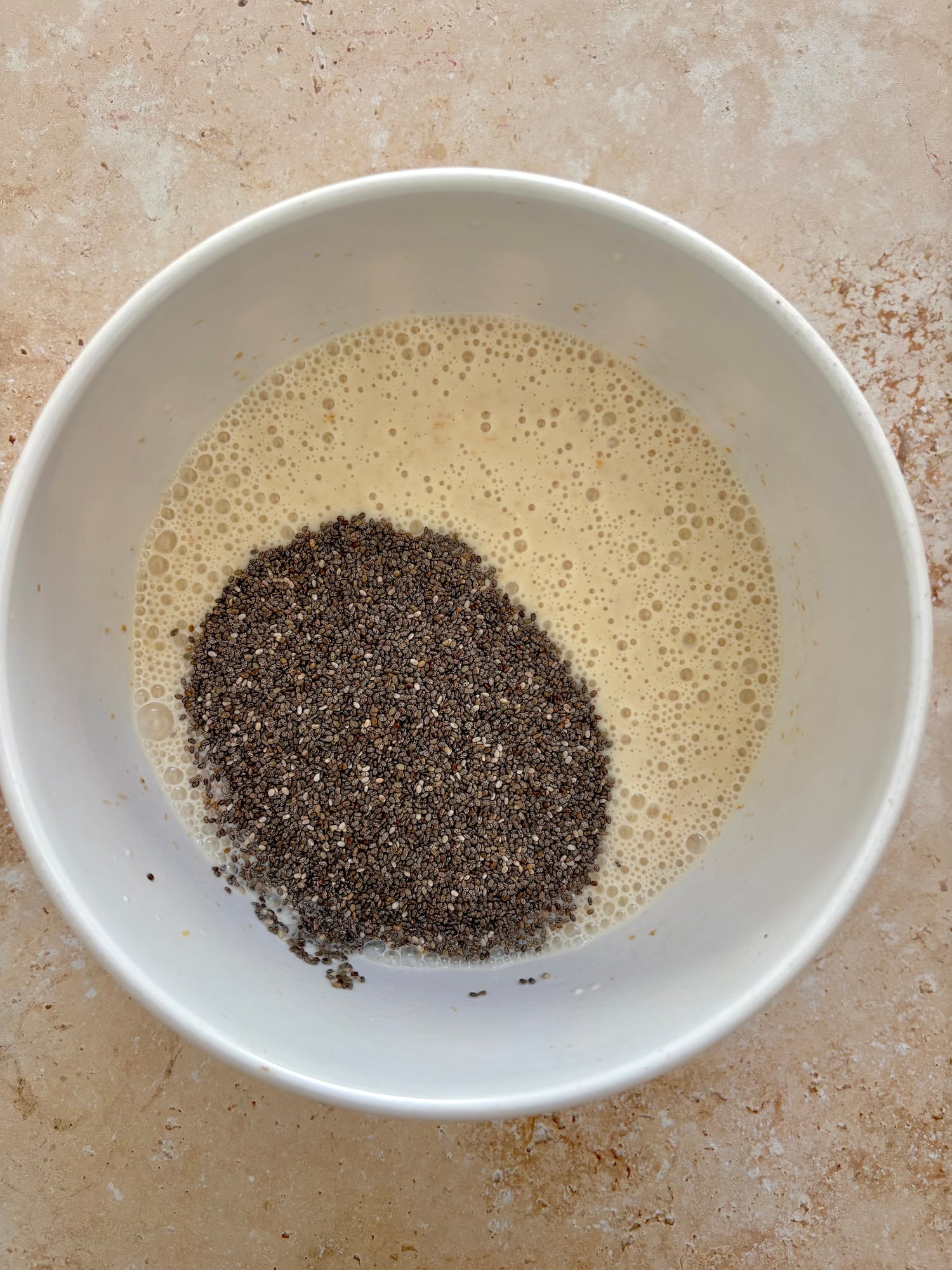yellow mixed liquid with a pile of black chia seeds.