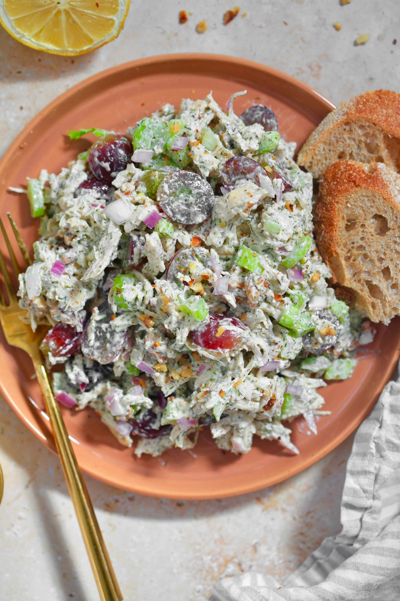 orange plate with colorful chicken salad on it with bread