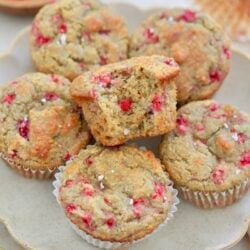 plate of raspberry muffins with bite taken out.