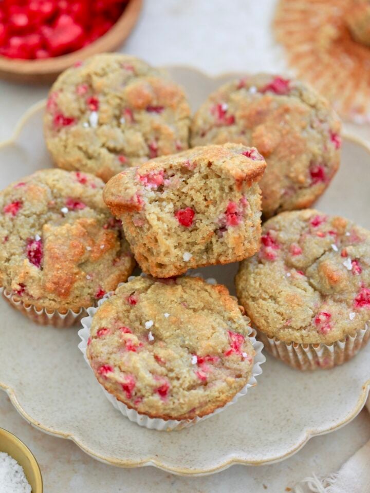 plate of raspberry muffins with bite taken out.