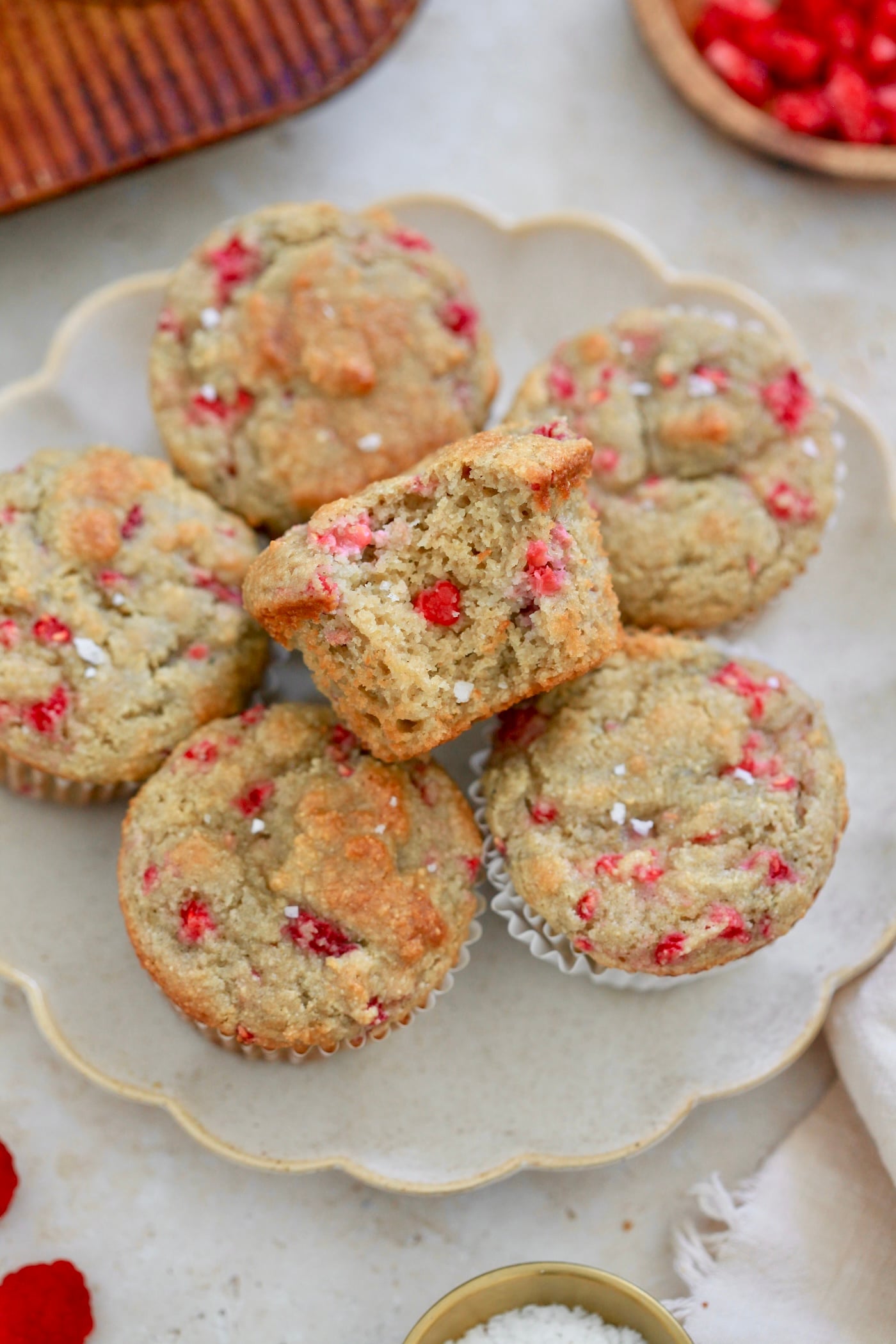plate of muffins with muffin tin in background.