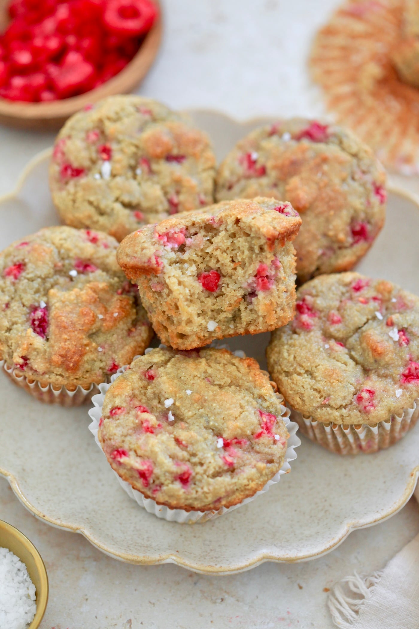 plate of raspberry muffins with bite taken out.