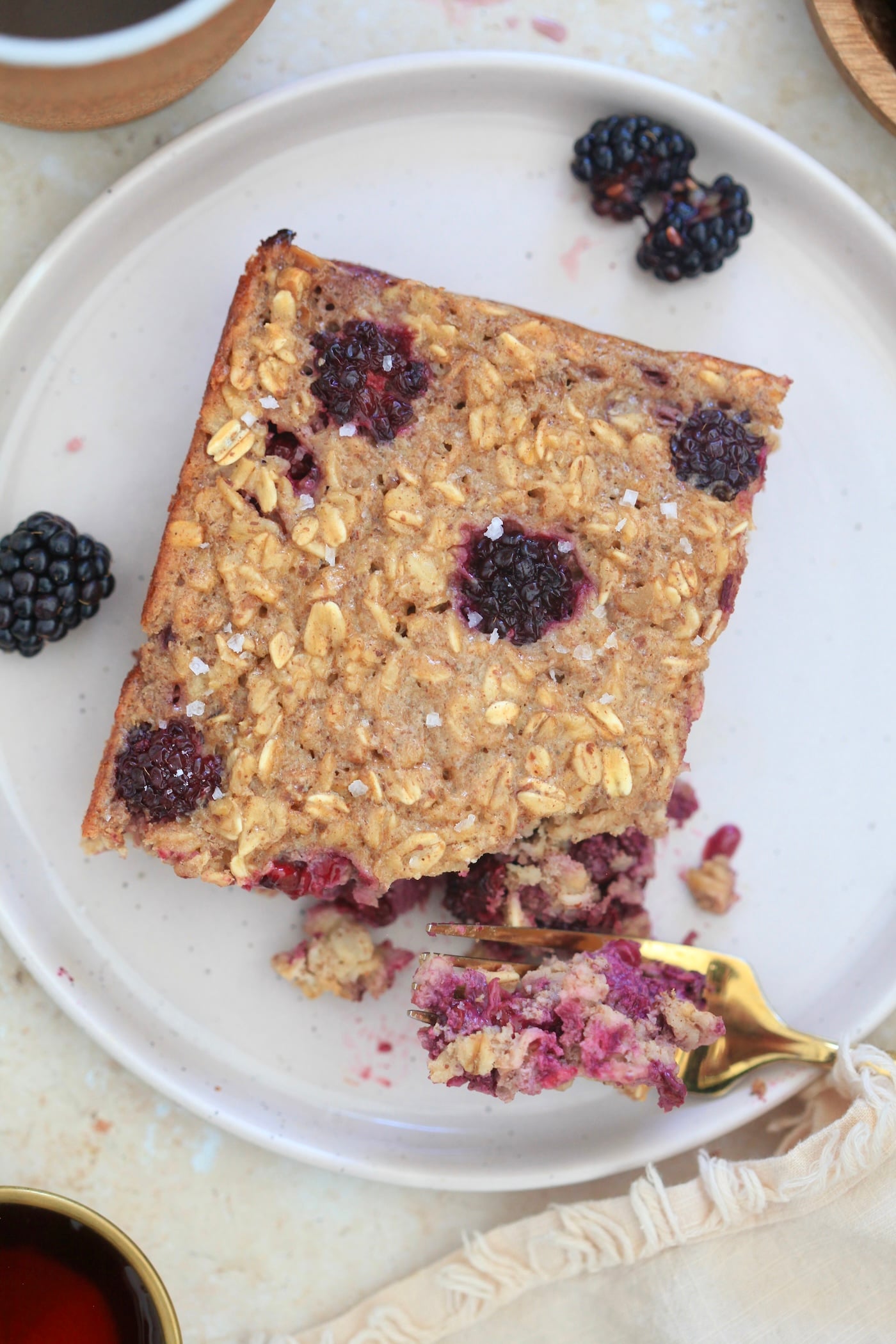 piece of oatmeal with blackberries and fork taking bite out