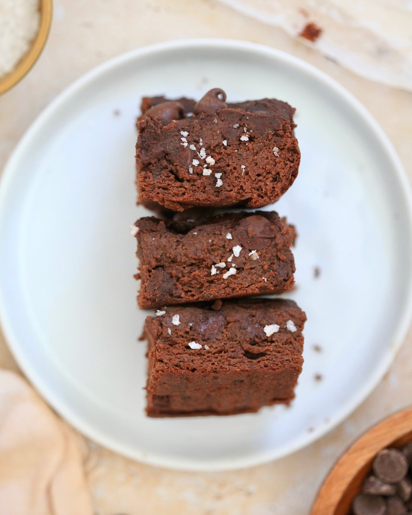 three brownies with salt face up on plate.