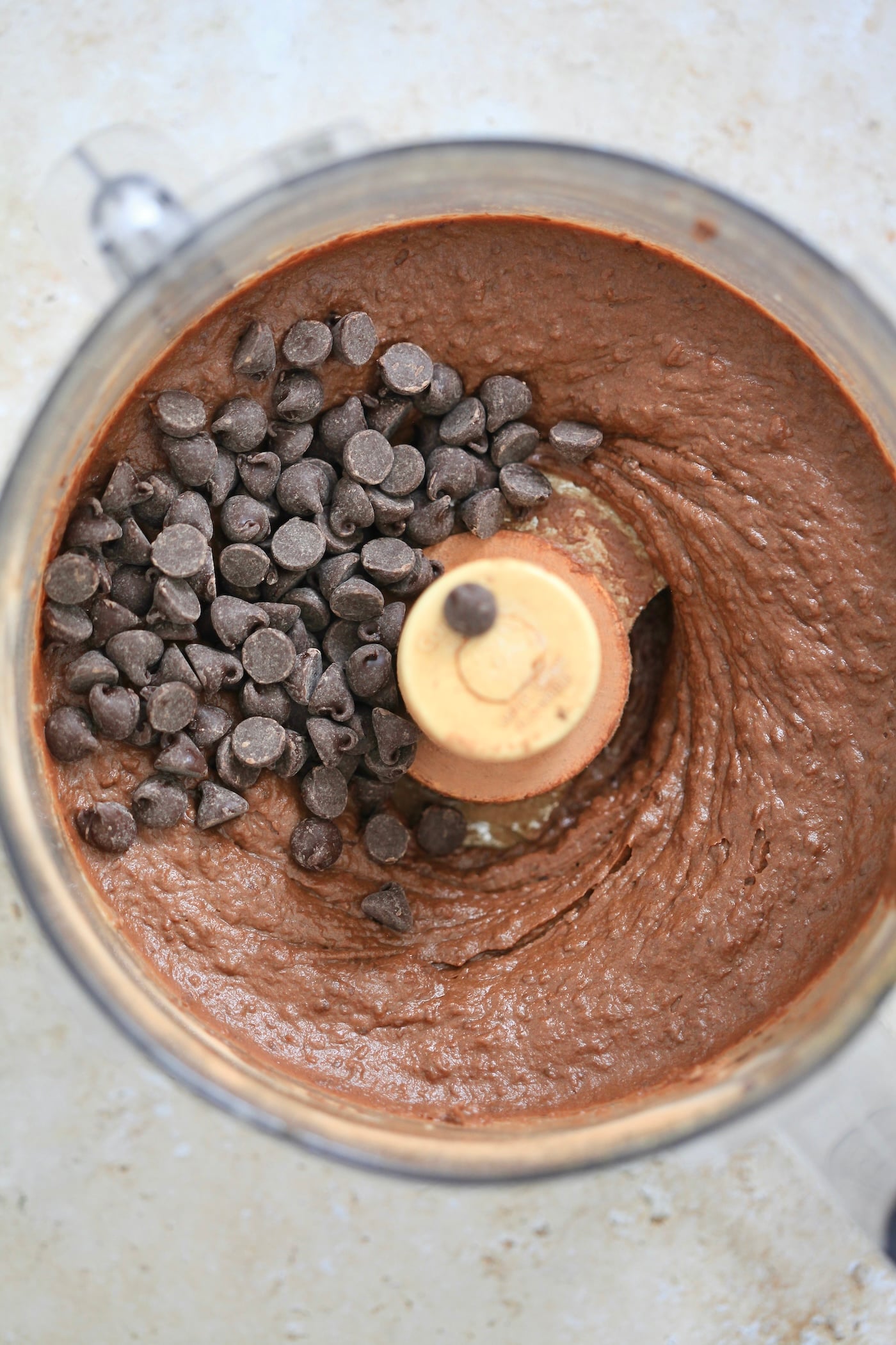 brown mixture in food processor with chocolate chips.