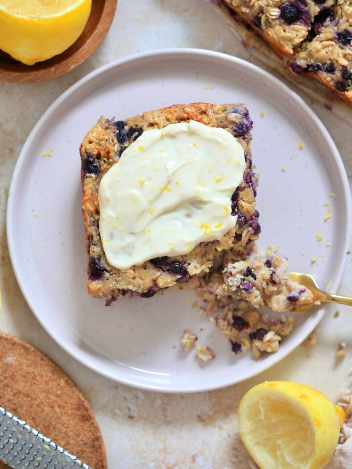 blueberry baked oatmeal with frosting and gold fork.