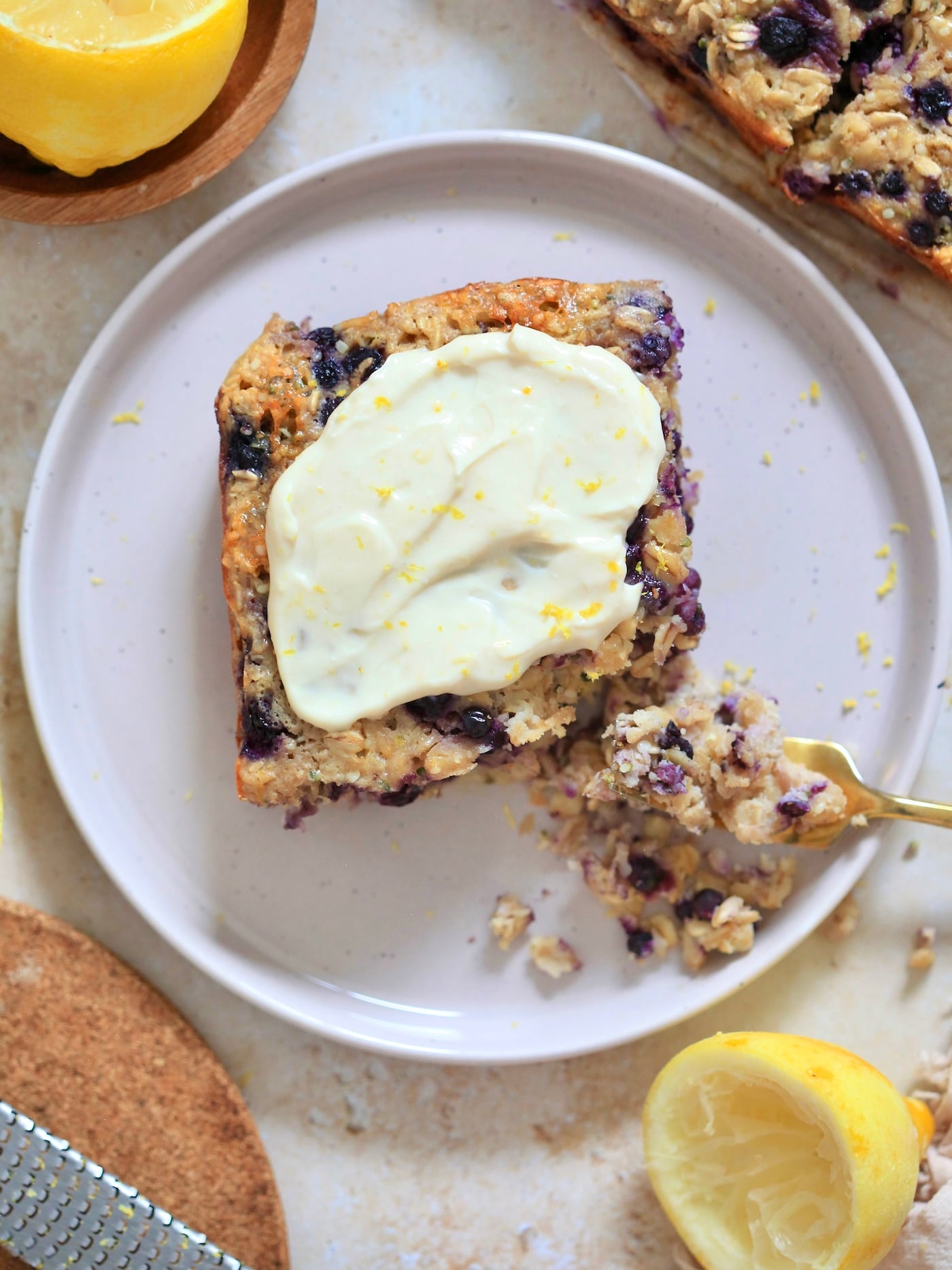 slice of blueberry baked oatmeal with frosting and lemons.