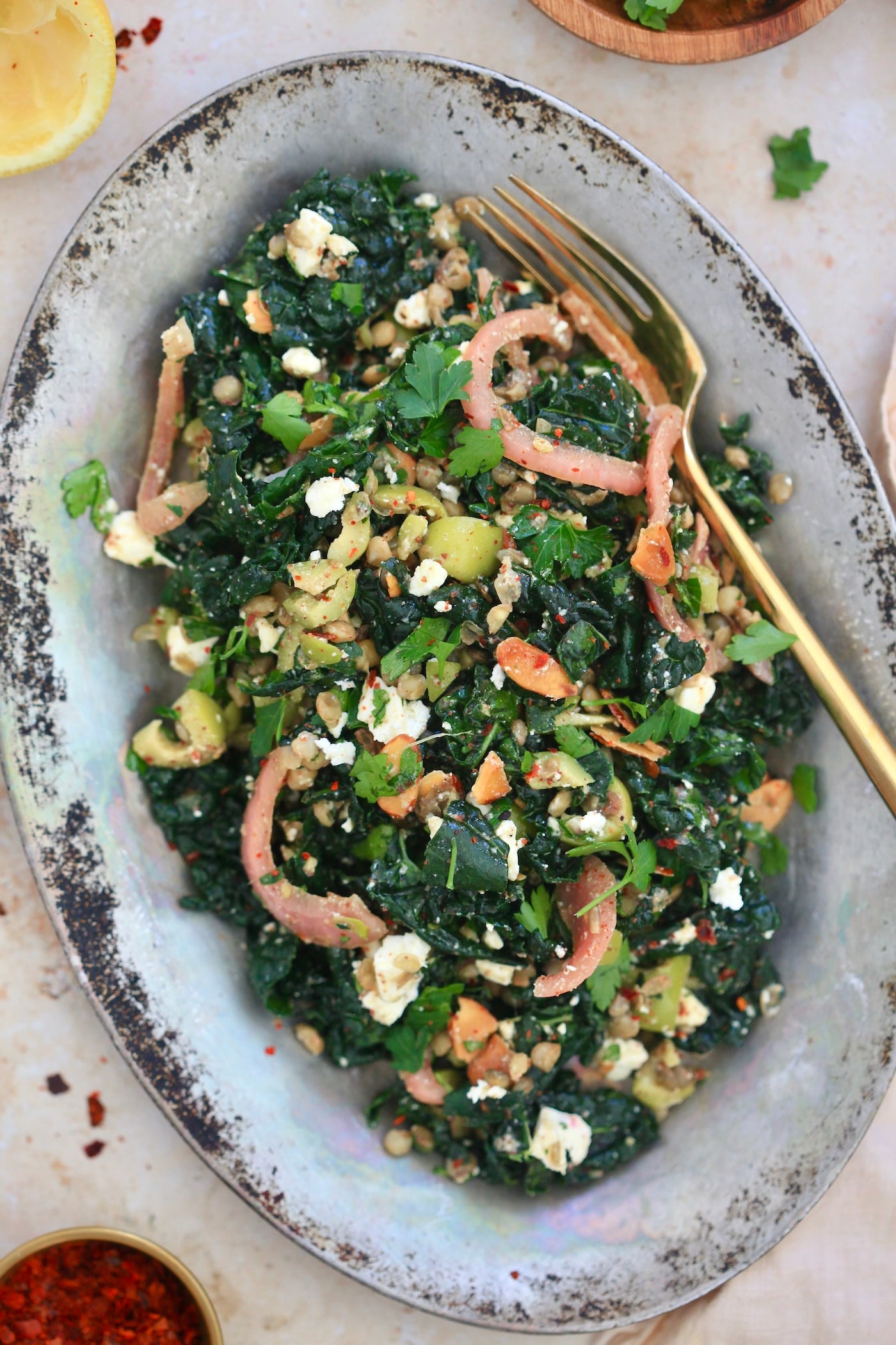serving dish with kale colorful salad and gold fork.